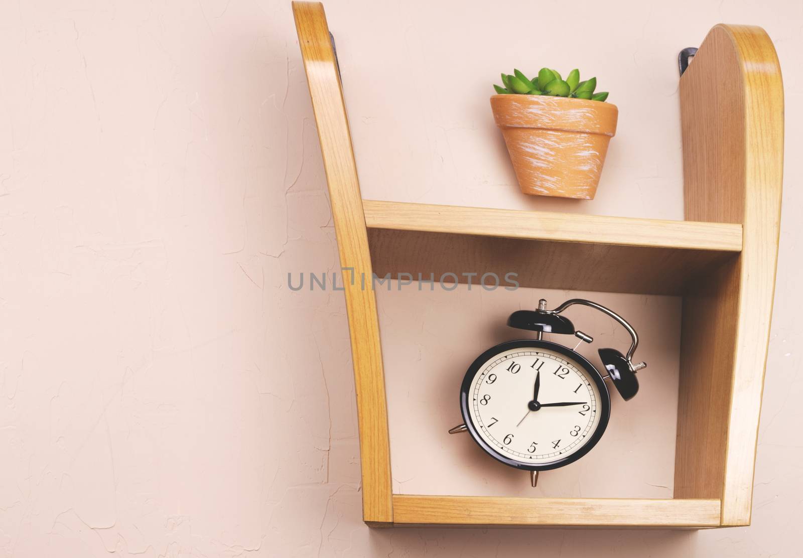 Flower alarm clock jumping on a wooden shelf