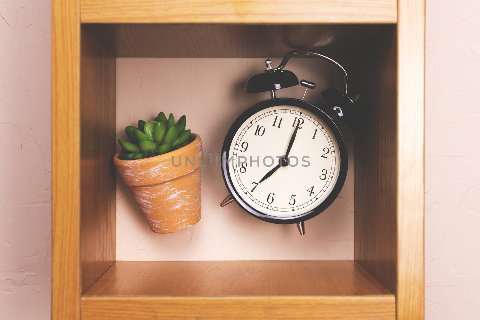 Flower alarm clock jumping on a wooden shelf