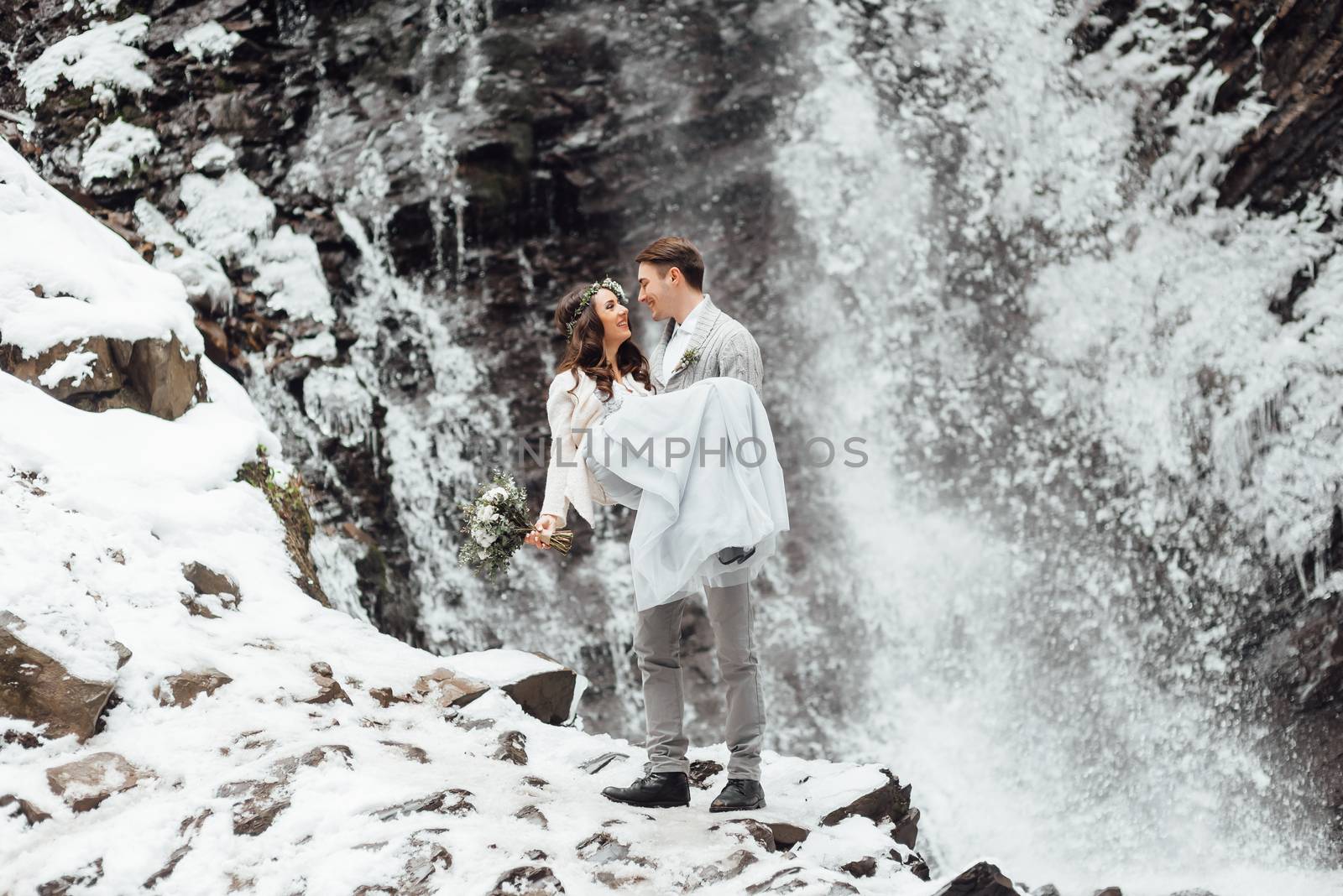 bride and groom on the background of a mountain waterfall