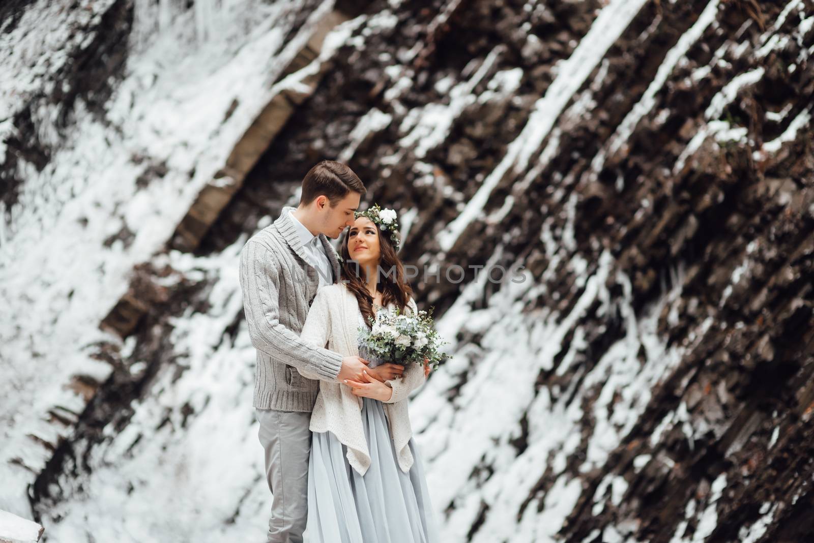 bride and groom on the background of a mountain waterfall