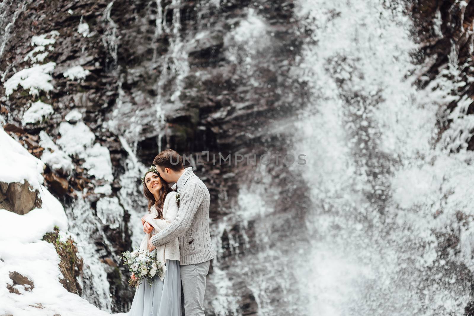 bride and groom on the background of a mountain waterfall