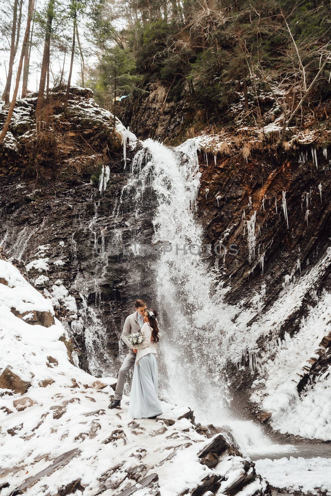 bride and groom on the background of a mountain waterfall