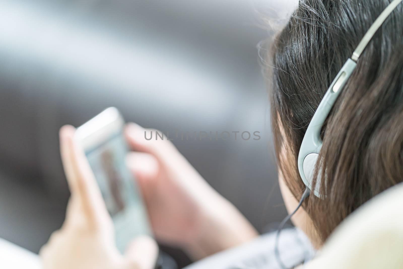 Asian woman listening music from mobile phone by stoonn