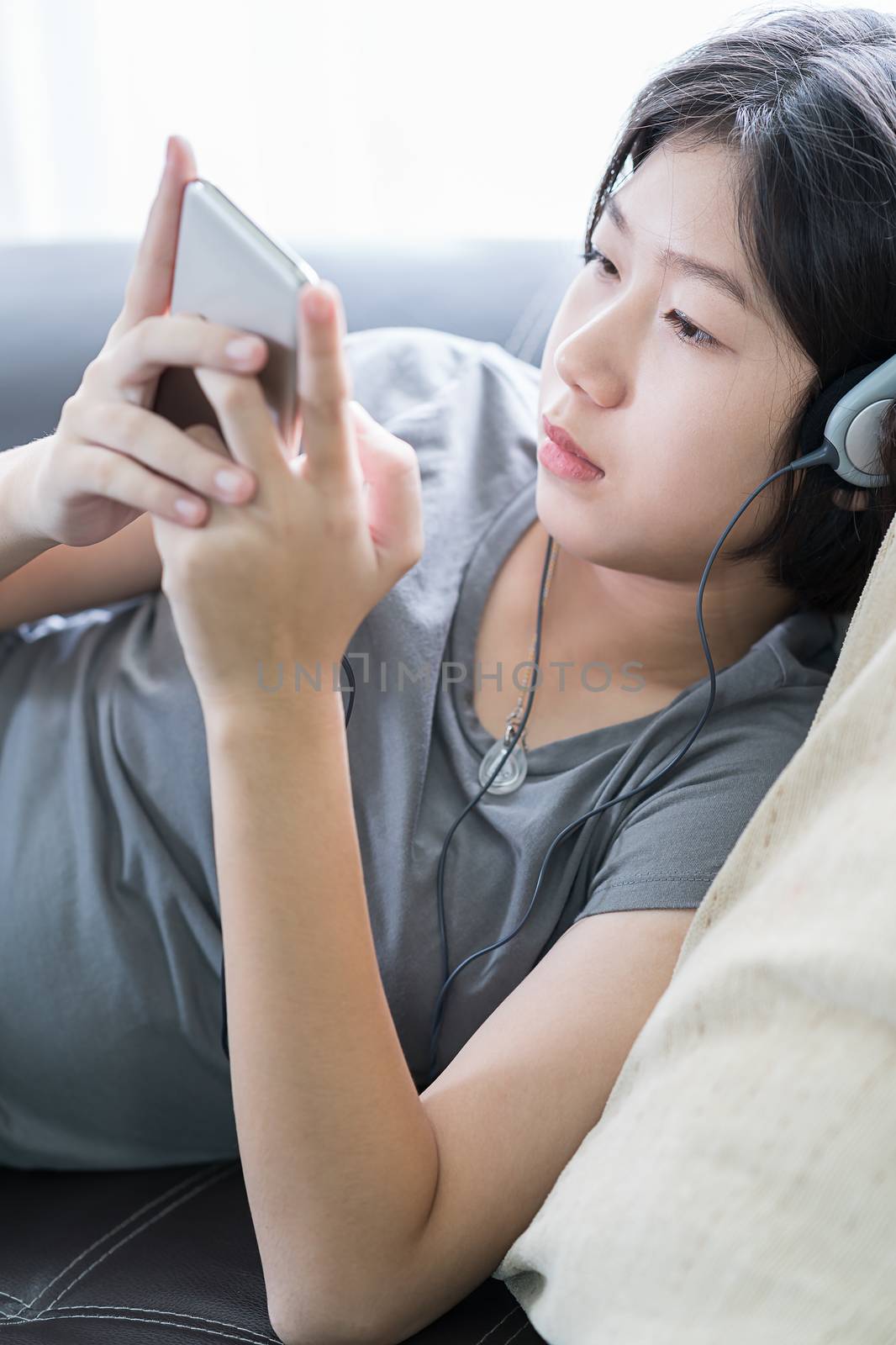 Asian woman listening music from mobile phone by stoonn