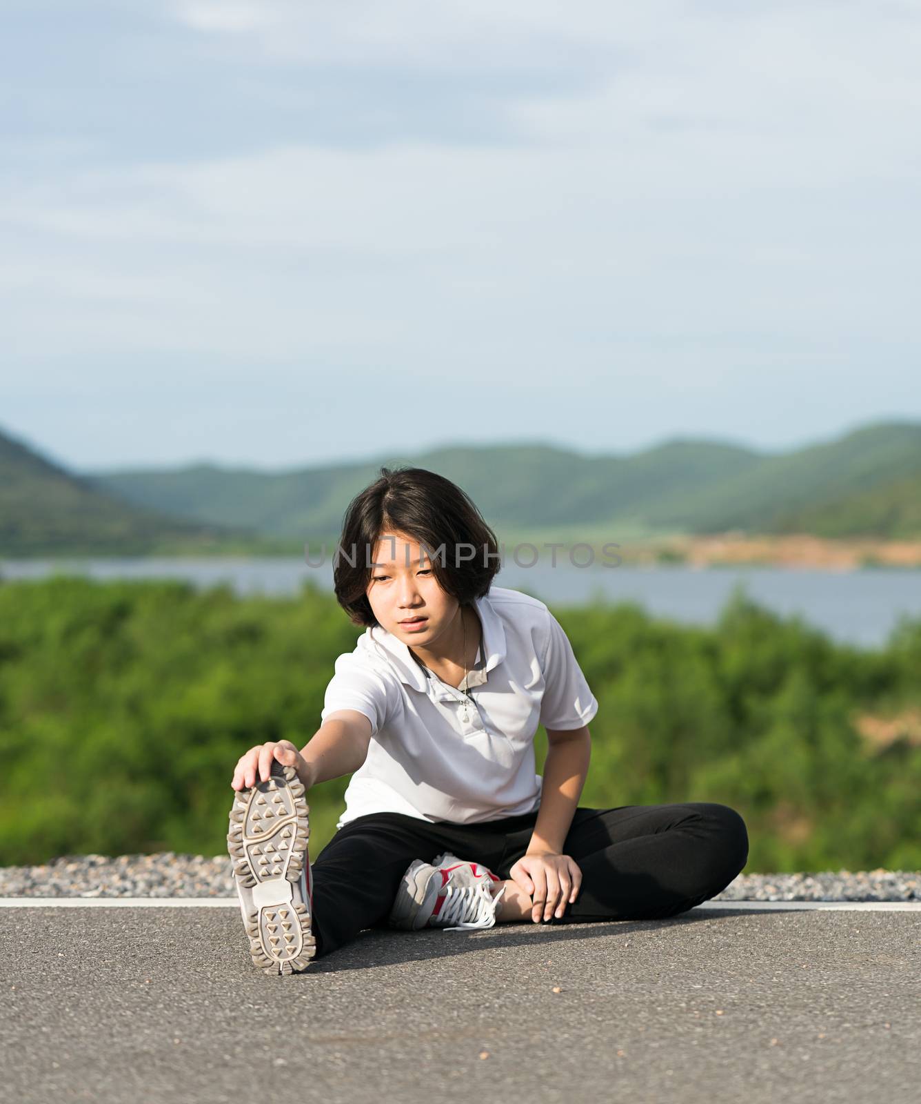 Woman runner doing exercises and warm up preparing for jogging outdoor