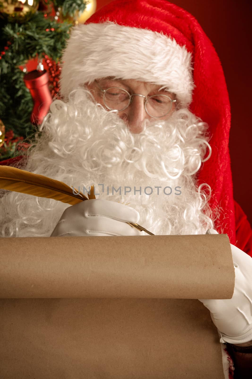 Santa Claus sitting at home and writing on old paper roll to do list with quill pen and ink