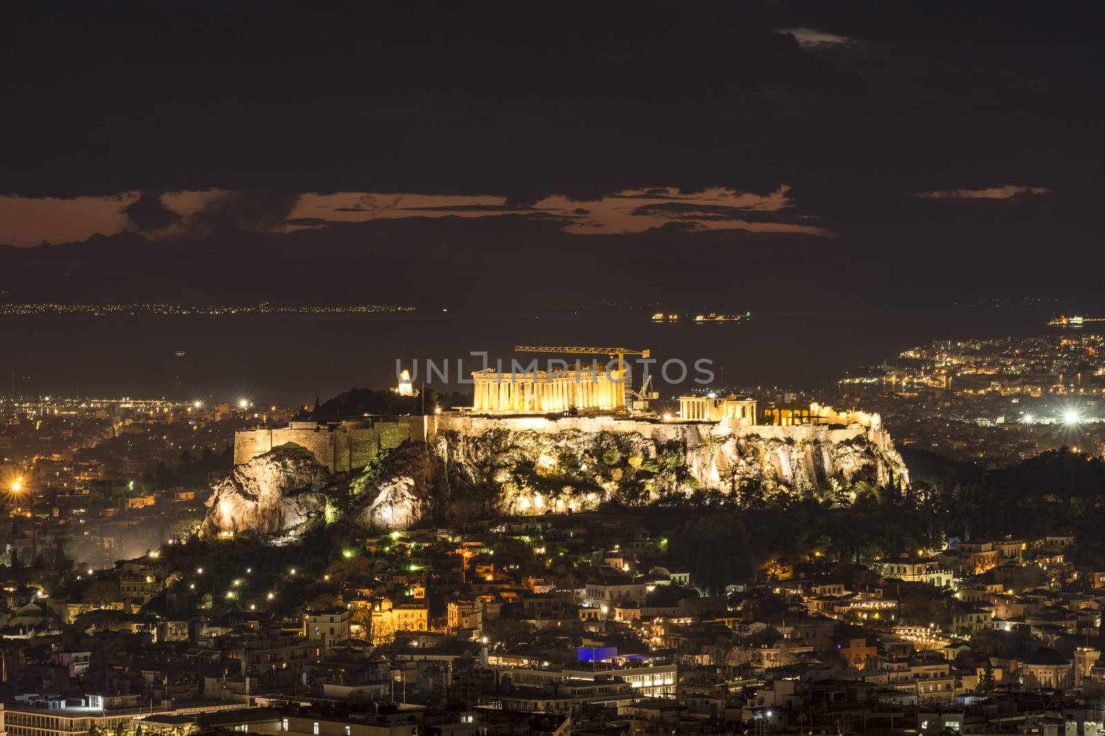 night shot of acropolis with part of athens city