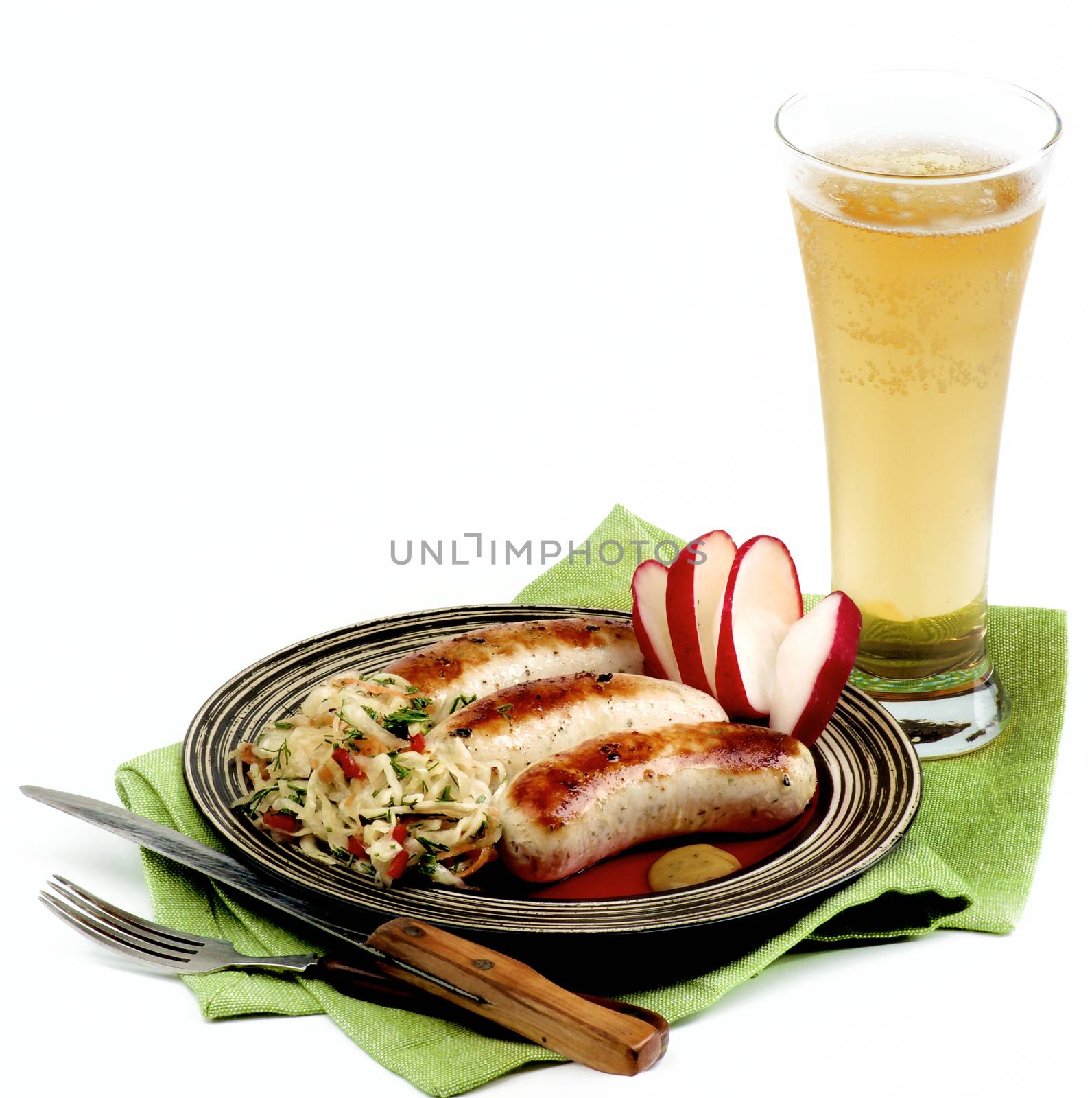 Delicious Grilled White Munich Sausages with Pickled Cabbage, Chopped Radish and Glass of Beer on Green Napkin isolated on White background
