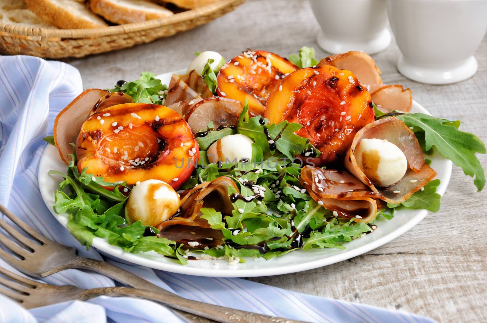 Salad with dried ham, grilled nectarine, mozzarella and arugula
