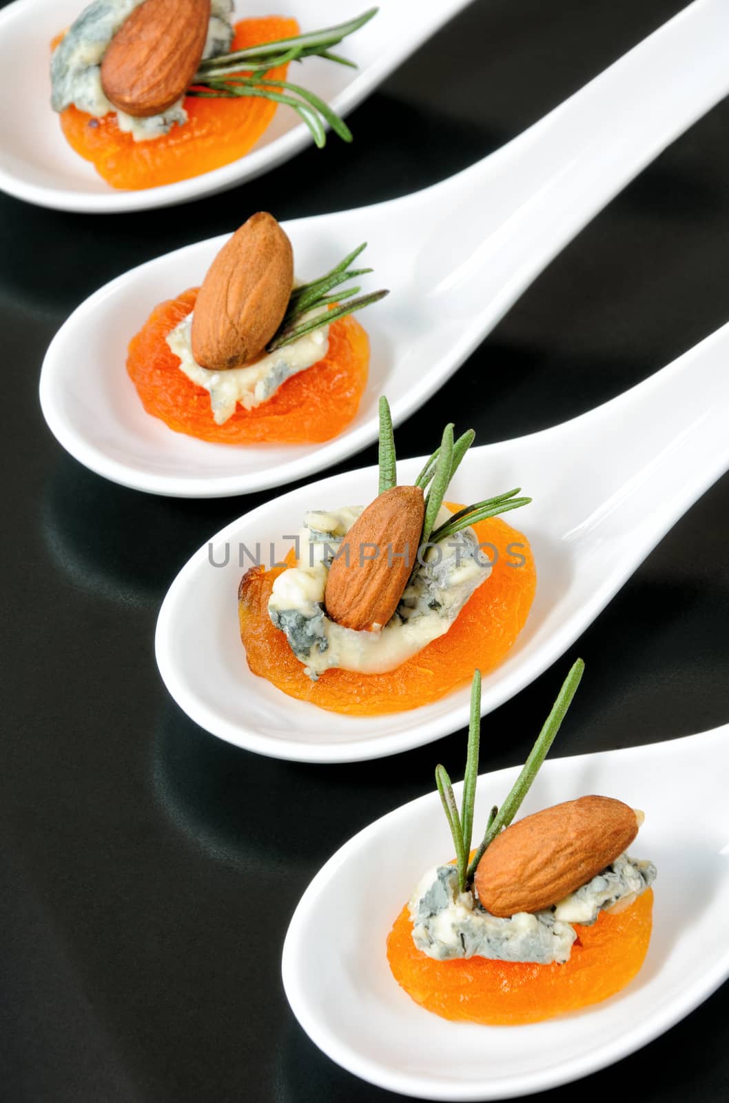 Cocktail snack from dried apricots with gorgonzola and almonds