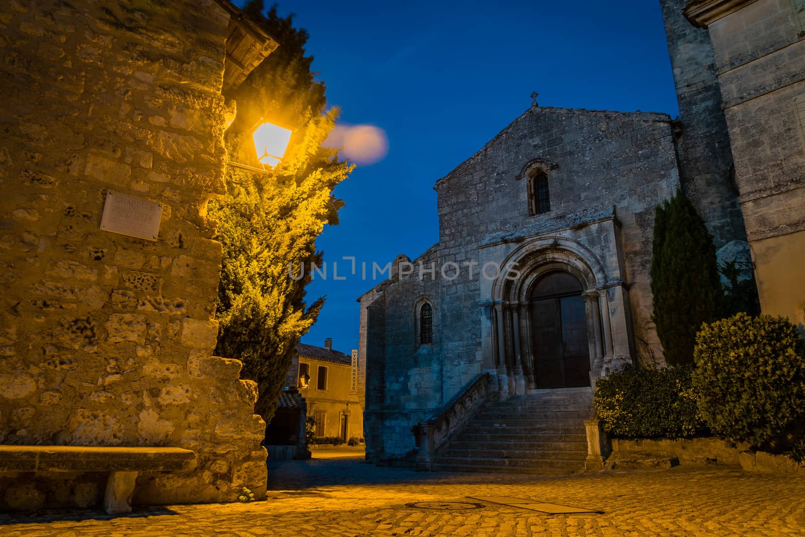 Baux-de-Provence church at night with a public light on the plaza