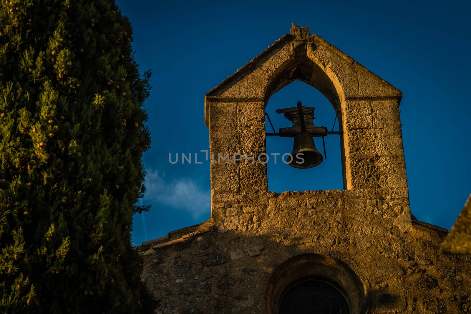 Baux-de-Provence church at night with a public light on the plaza