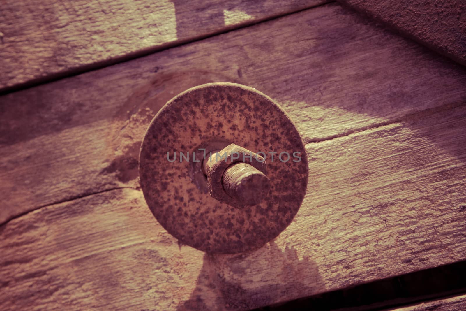 The screw nut is rust on old wood floor.