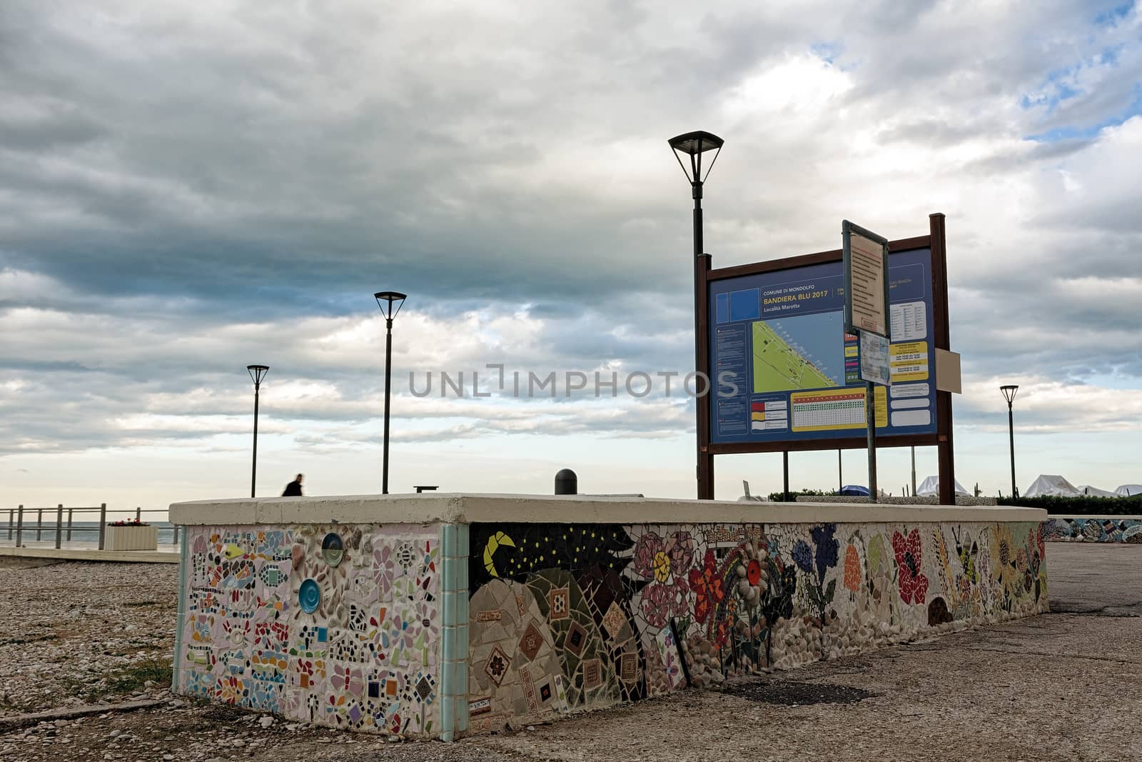 The mosaic on the wall in the seafront of Marotta under a cloudy sky, Italy