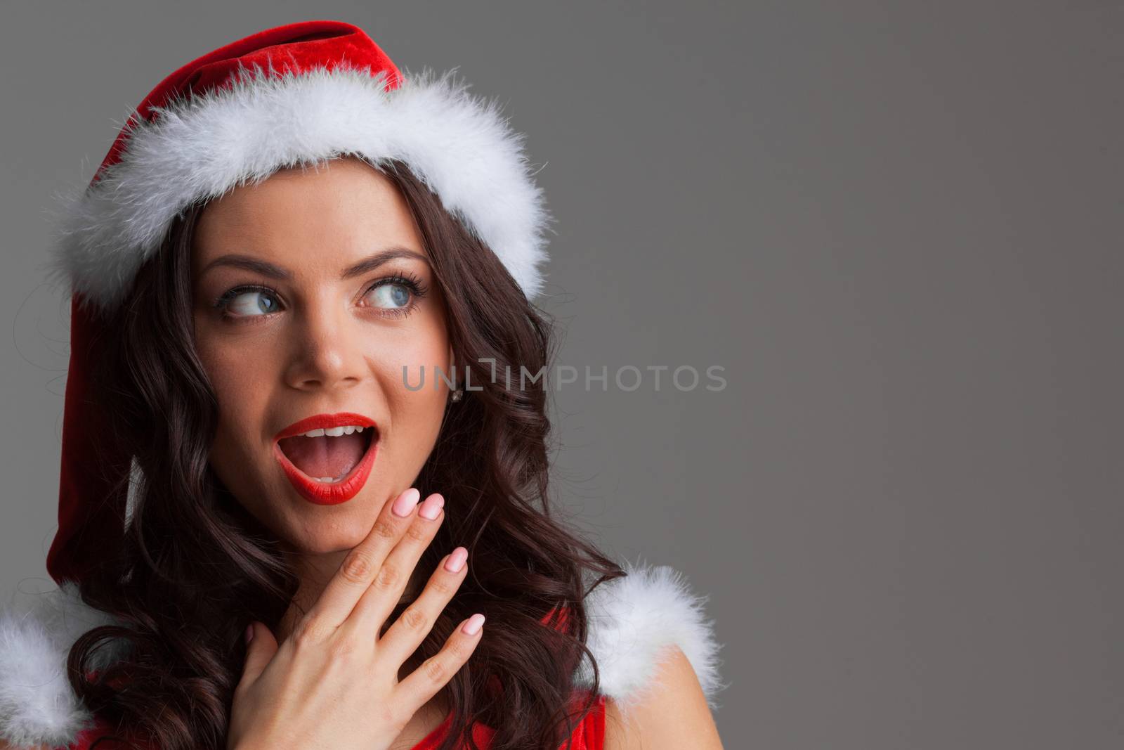 Pretty Pin-up style Santa girl in red hat on white background