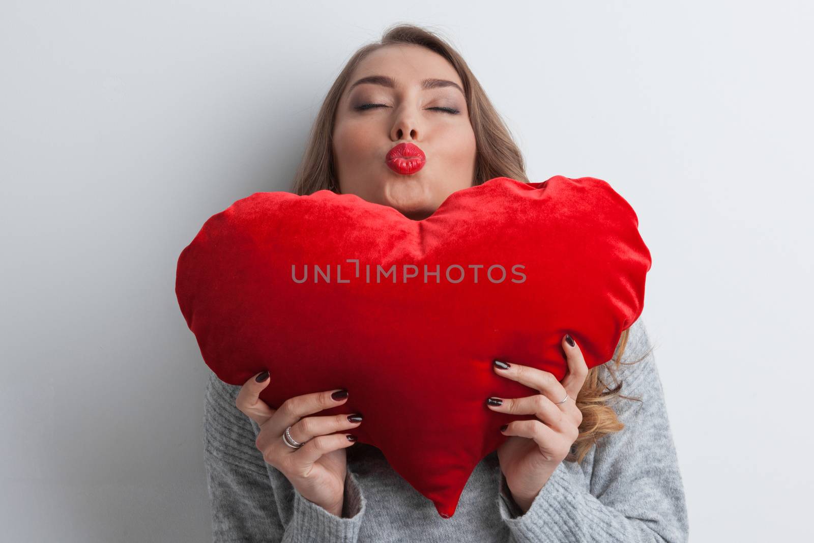 Beautiful woman with red pillow heart, valentine's day concept