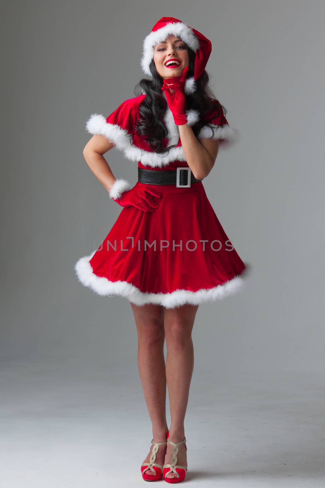 Beautiful woman wearing santa claus costume, full length portrait
