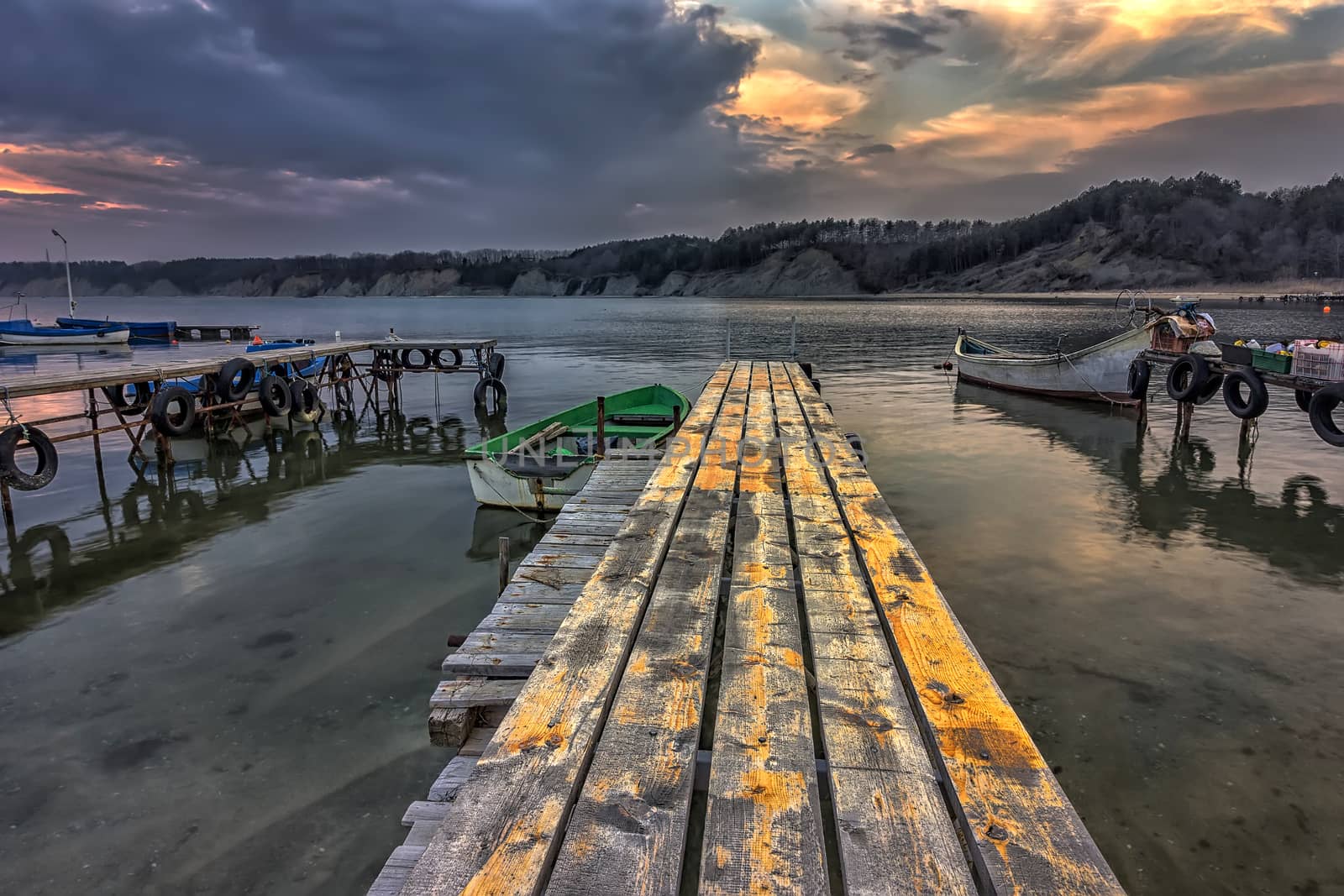 exciting landscape of wooden pier and boats at sunset