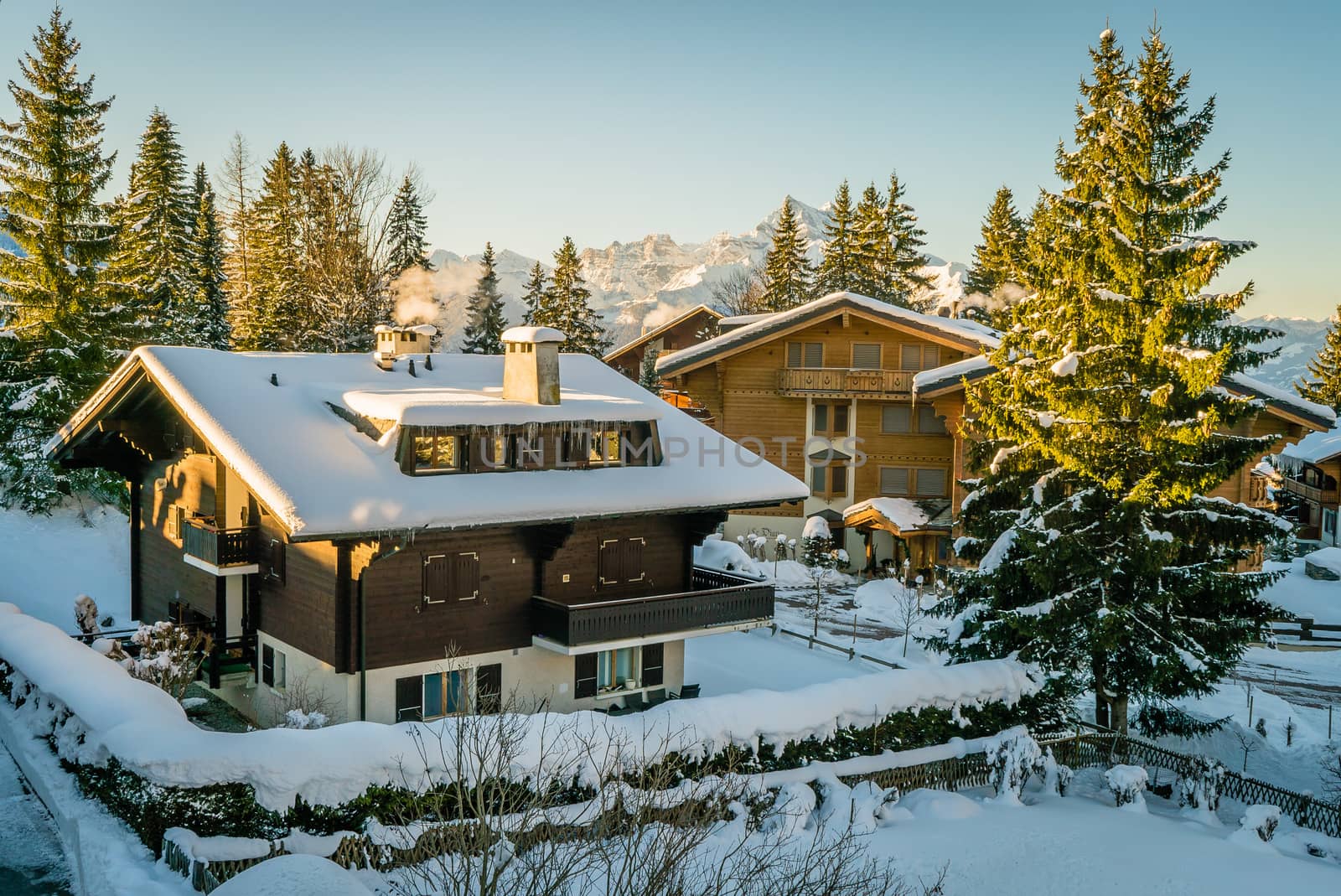 Houses covered with snow in Switzerland on a sunny morning