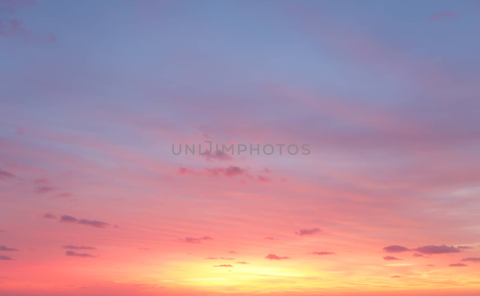Morning sunrise skies with colours of yellows, rich reds and blues in the sky above with some light cloud