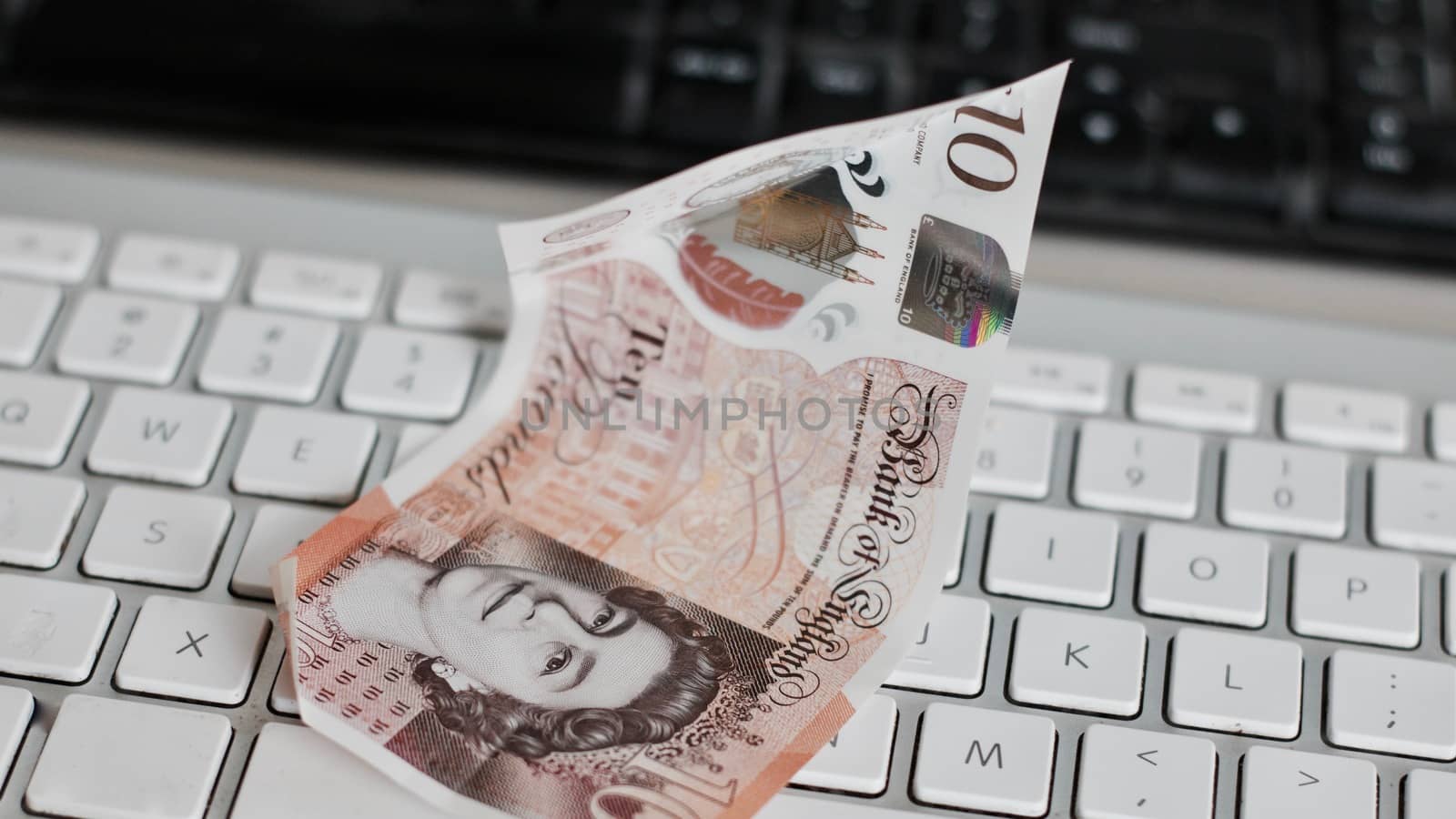 British money on the white keyboard in the office. Money concept.