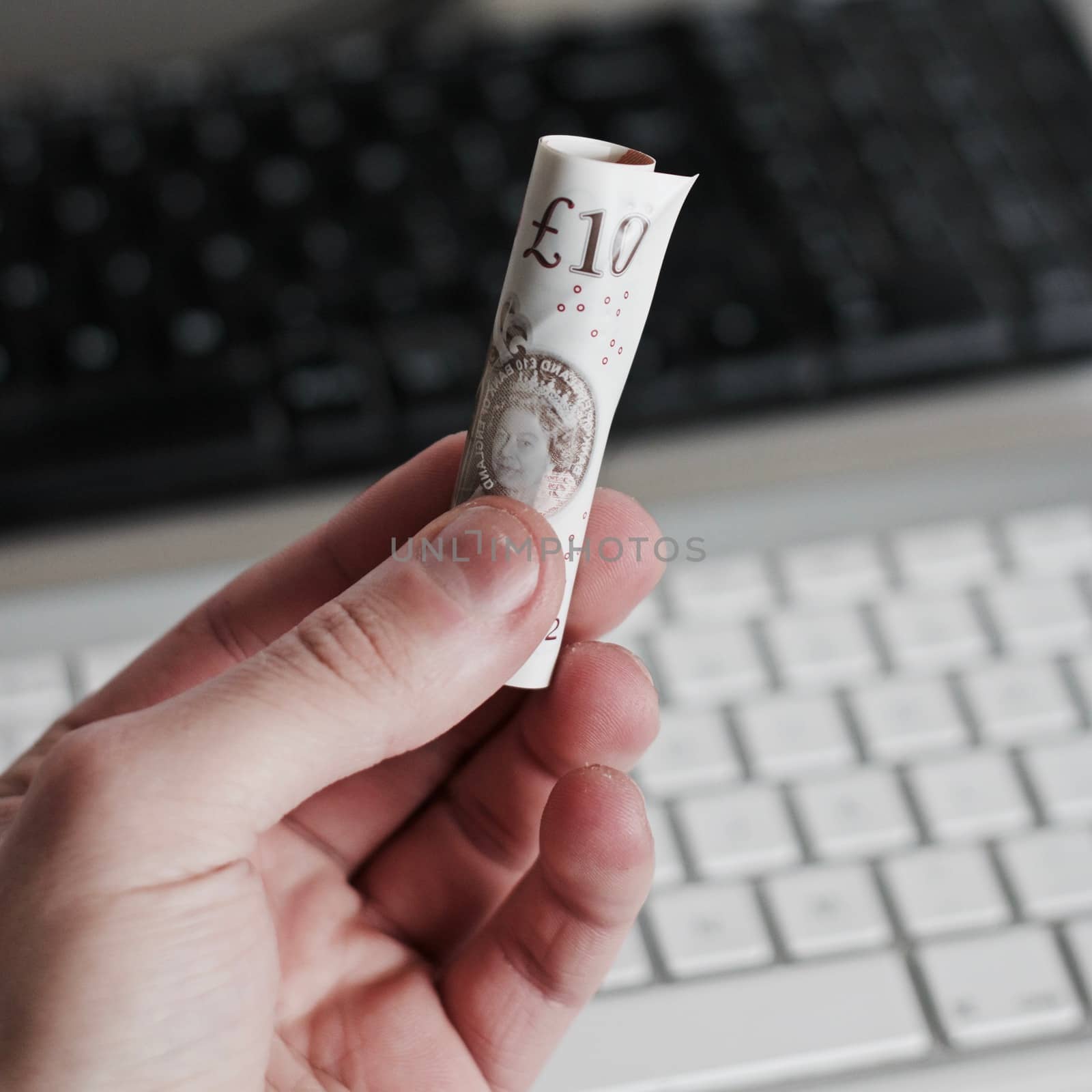 British paper money in hand near white computer keyboard. Money concept.