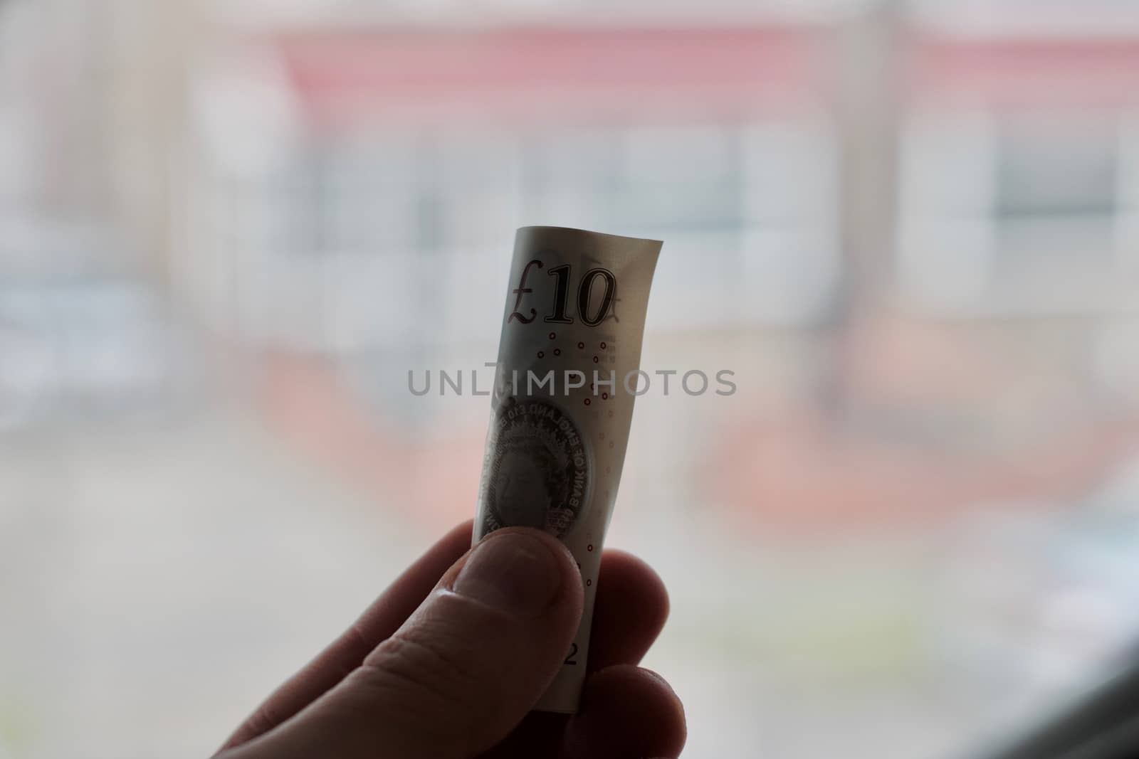 British paper money in hand near white computer keyboard. Money concept.