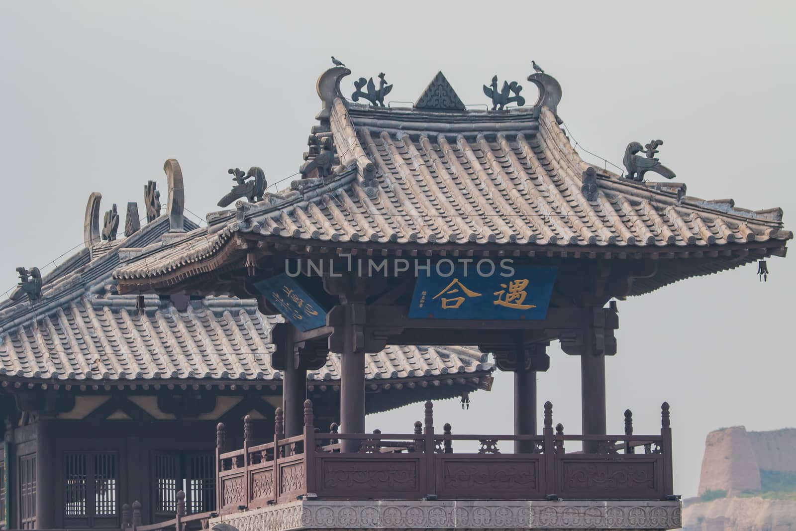 Close up of a Ming Dynasty look out tower with part of an original section of the Great Wall of Chinna in te background