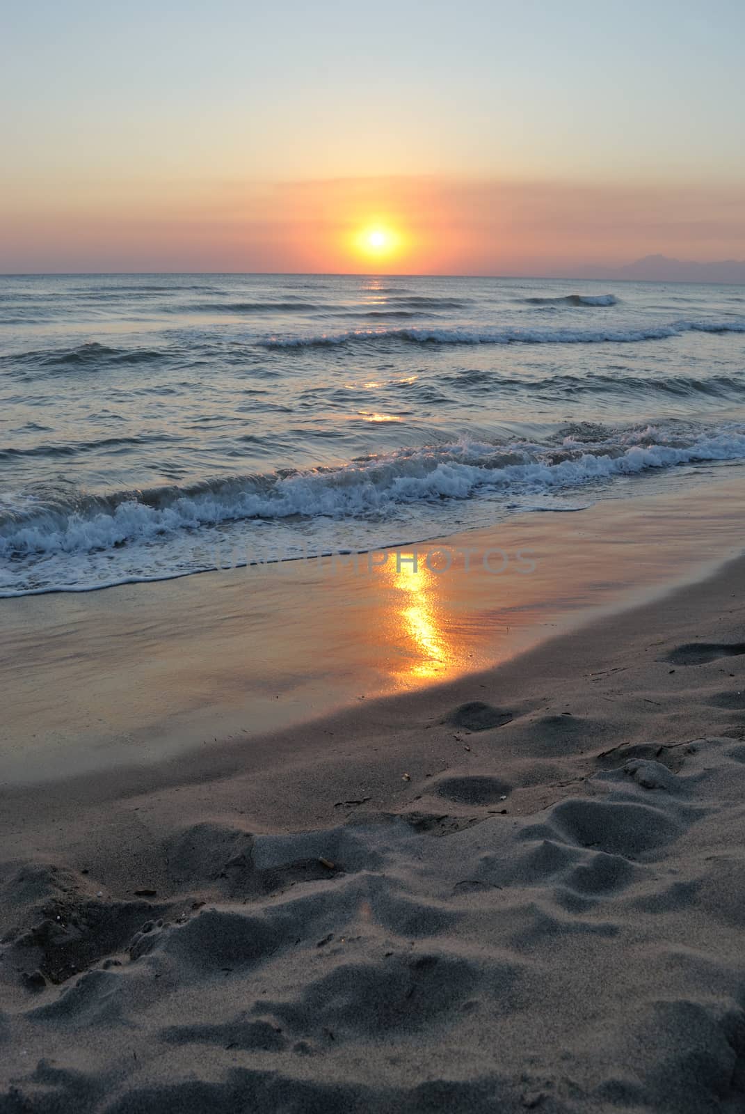 romantic sunset reflected on the beach, vertical