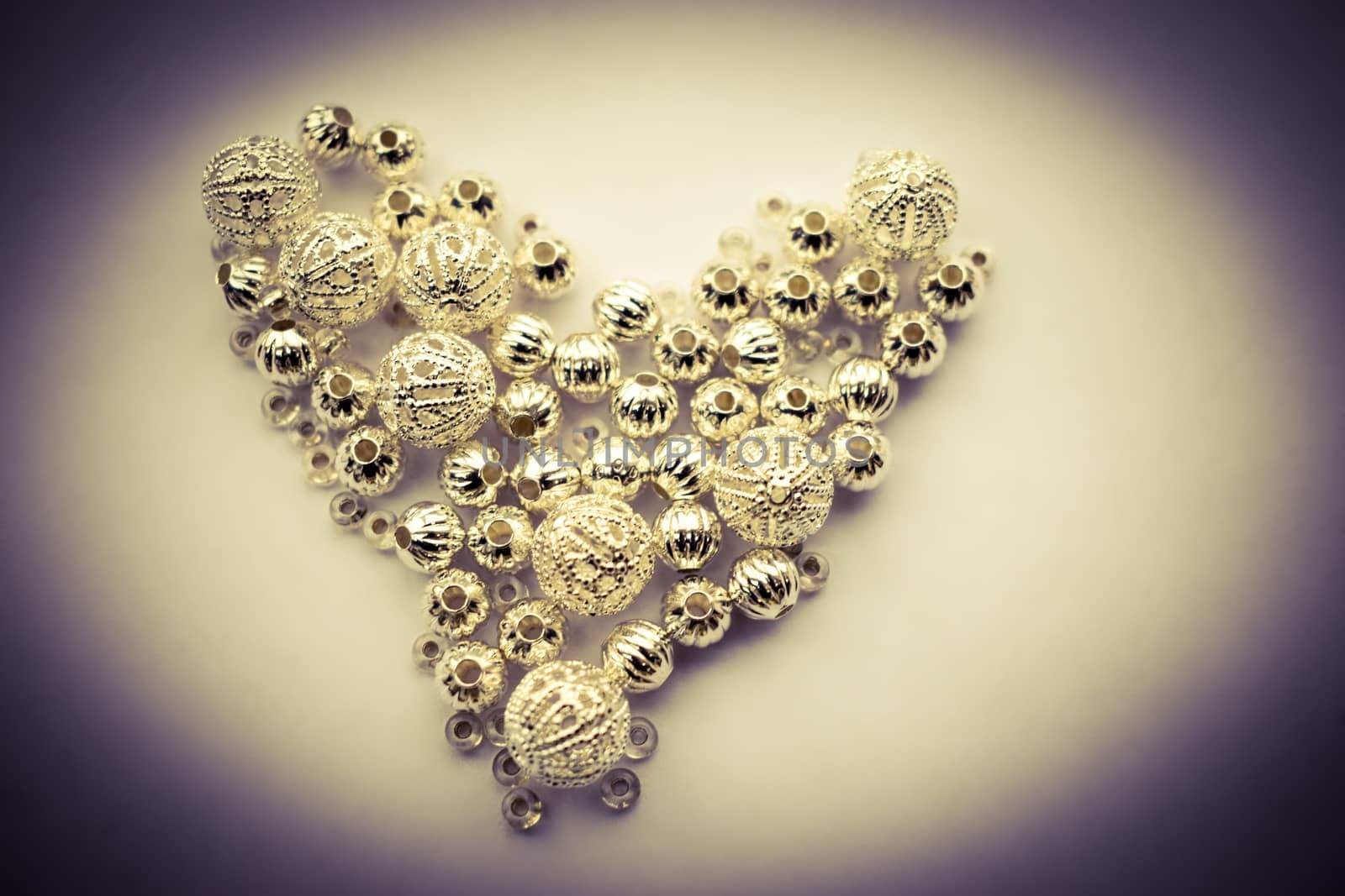 selection of different silver beads shaped into a heart