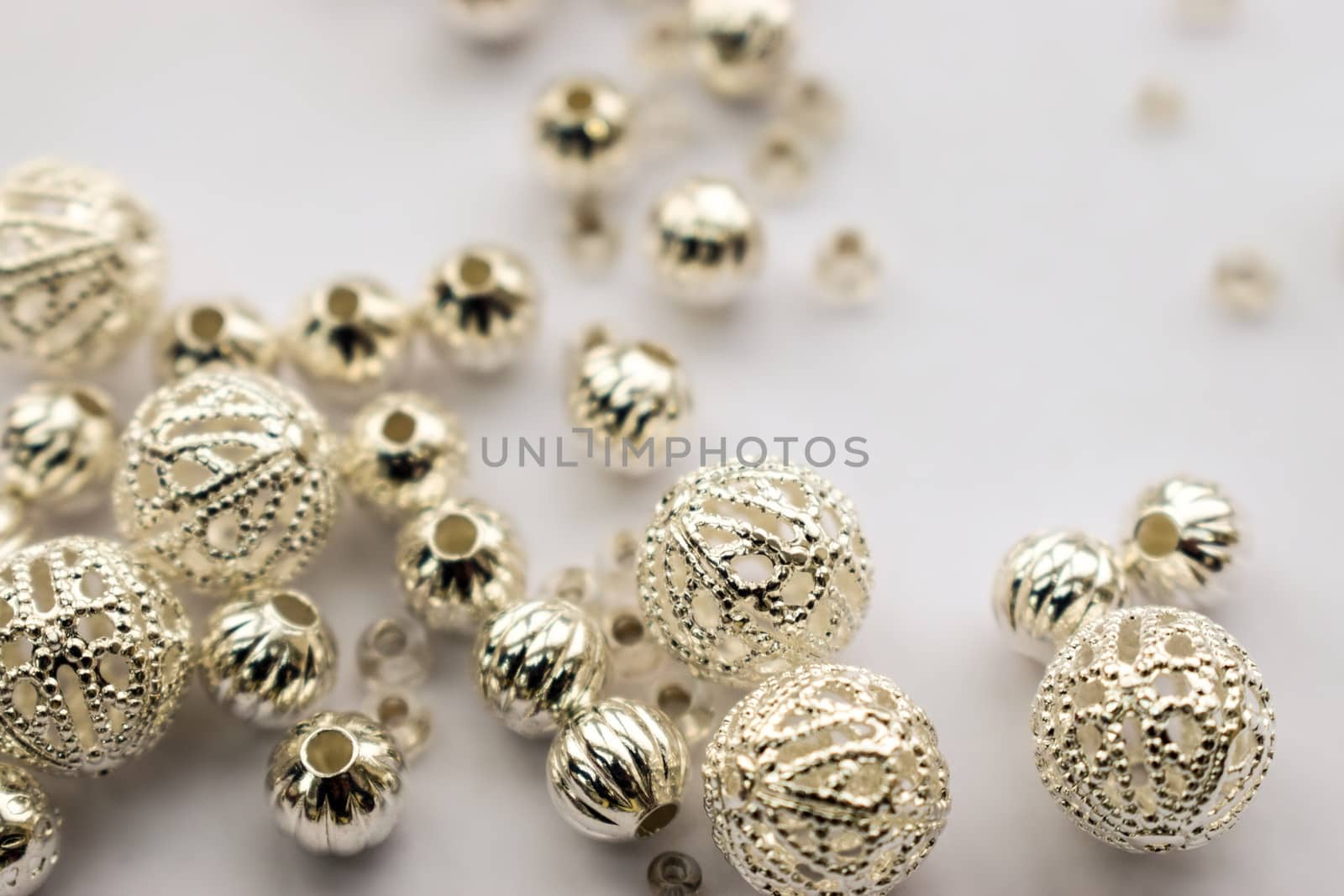 selection of scattered silver beads on white background