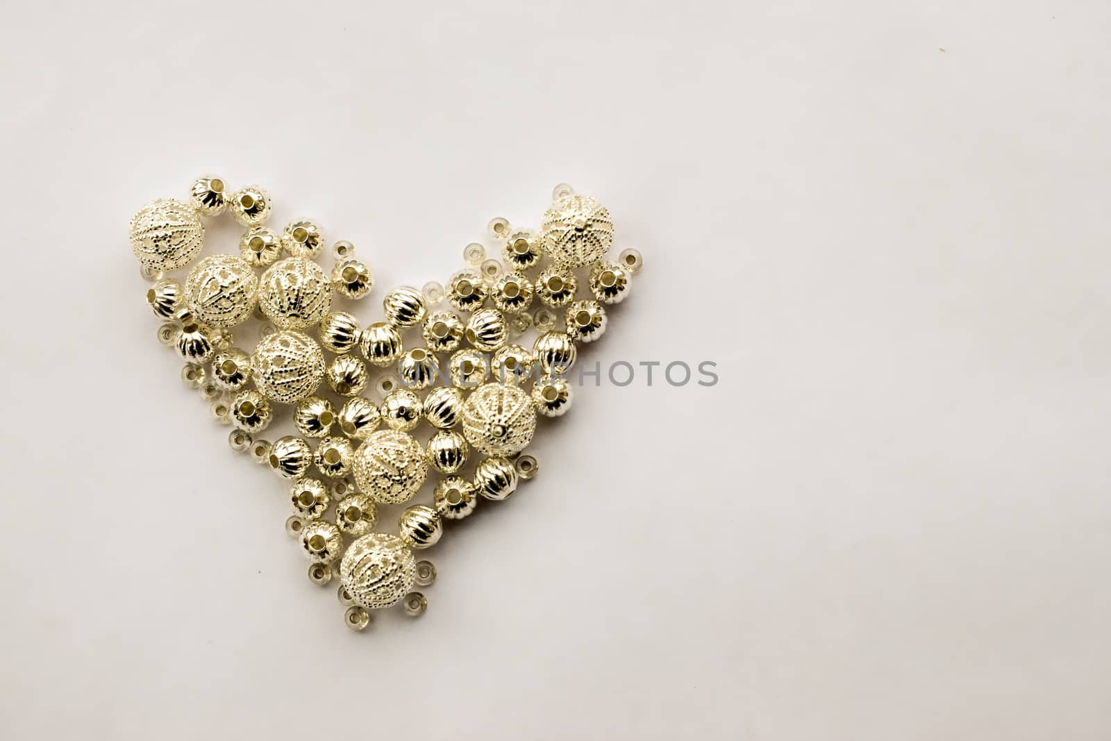 selection of different silver beads shaped into a heart