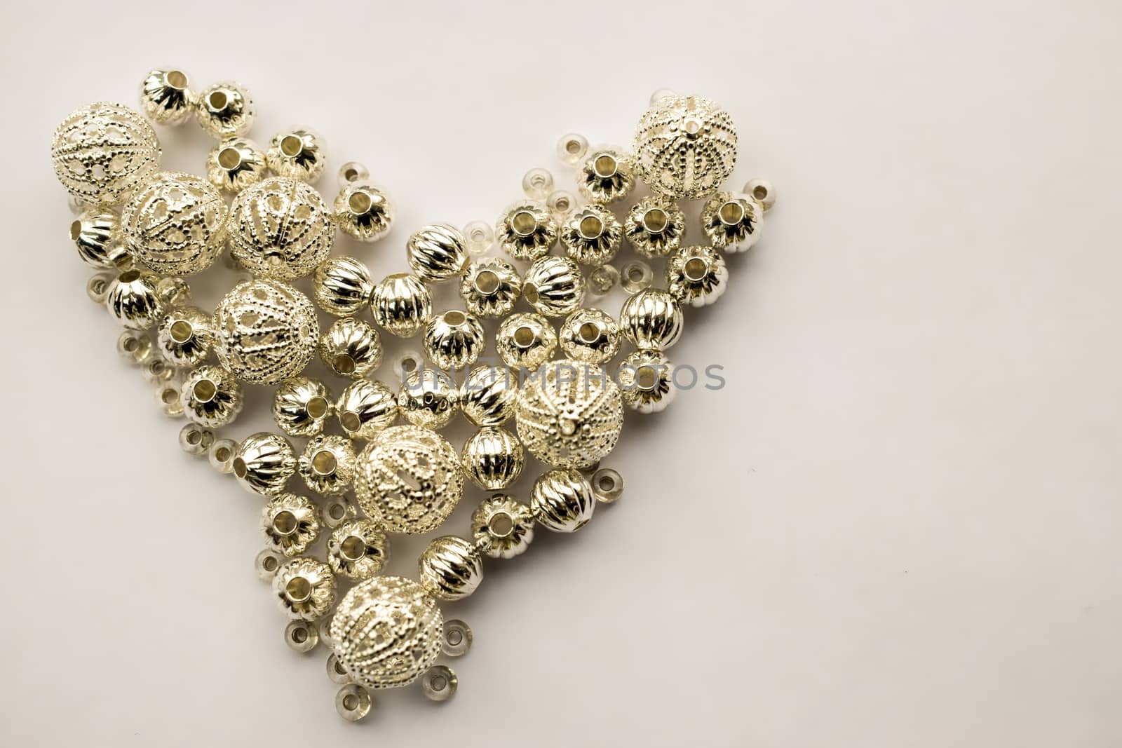 selection of different silver beads shaped into a heart