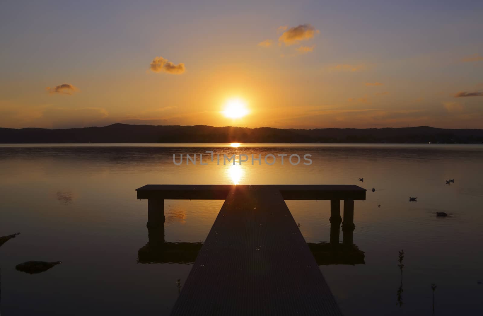 Sunset over the jetty with reflection in waters