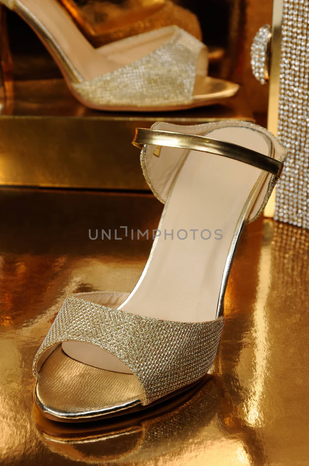 Couple of gold shoes on a gold background close-up