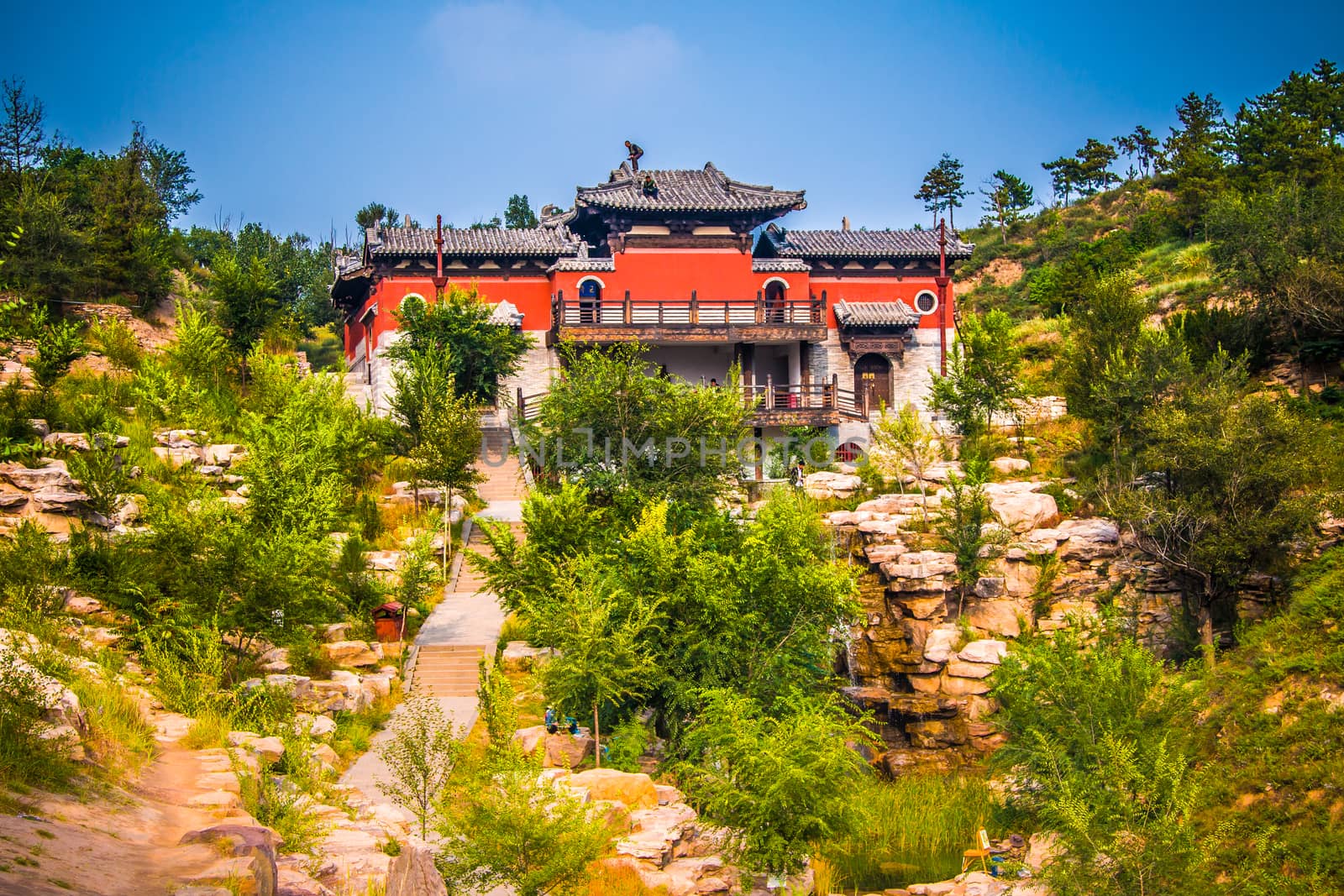 A buddhist monastery on top of a cliff under going renovations.