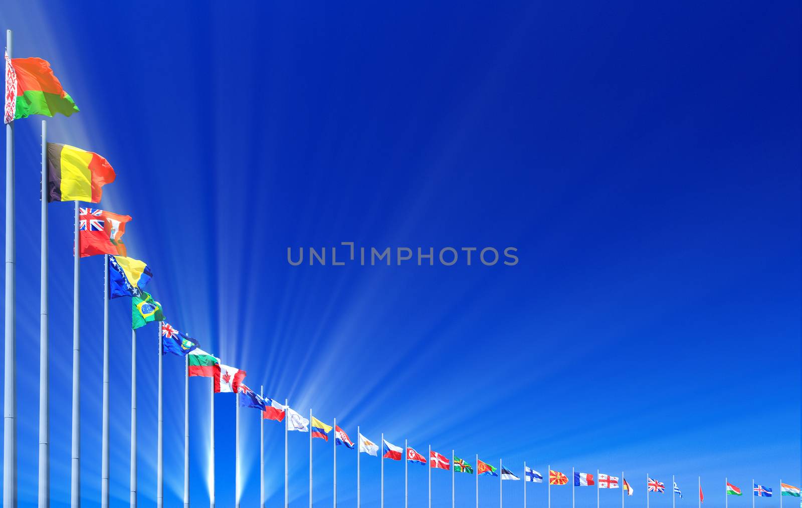 Flags and sunbeams against blue sky, copyspace