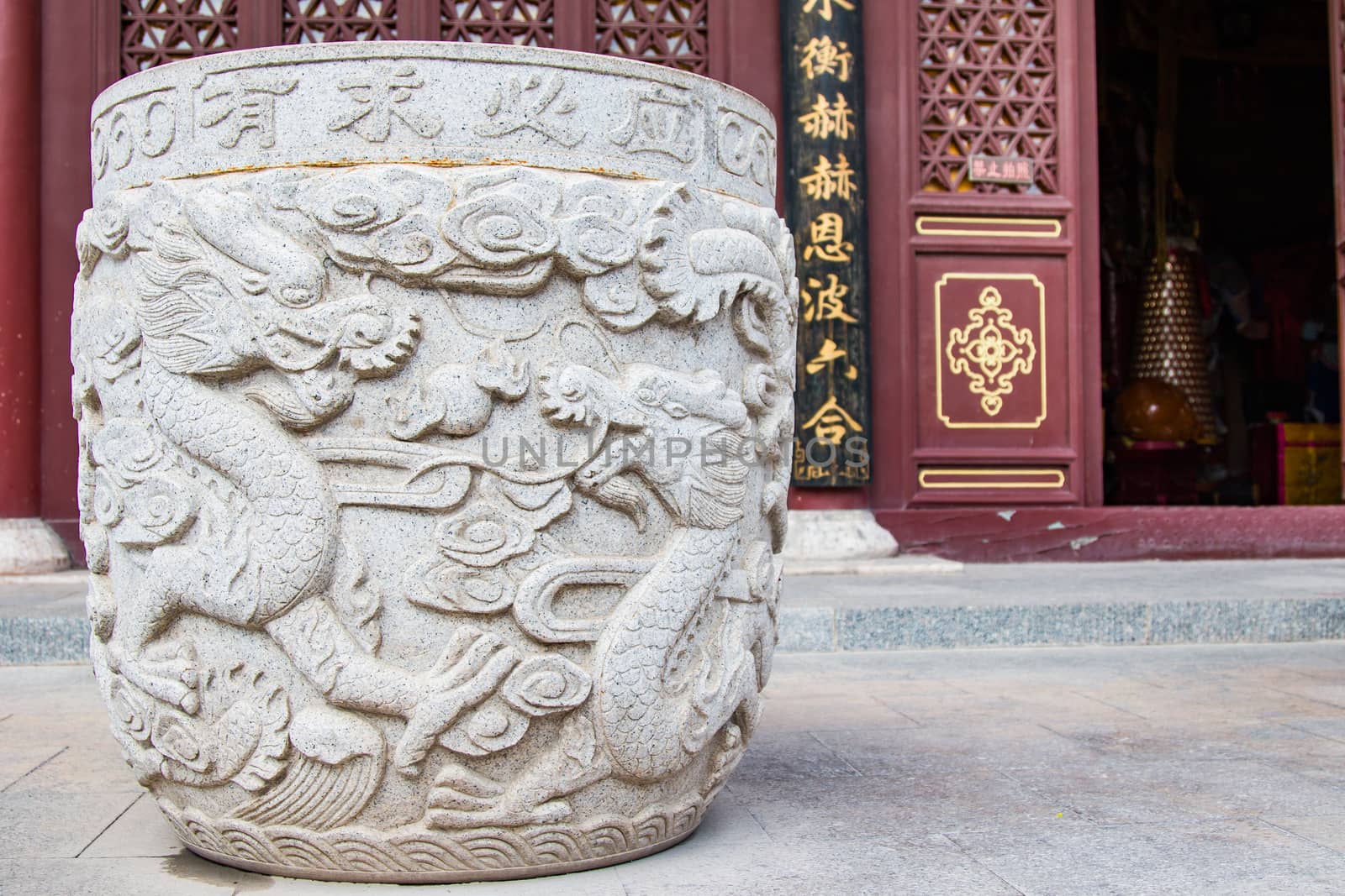 A giant Ming Dynasty stone urn with a double dragon motif adorns the entrance way to a prayer room.