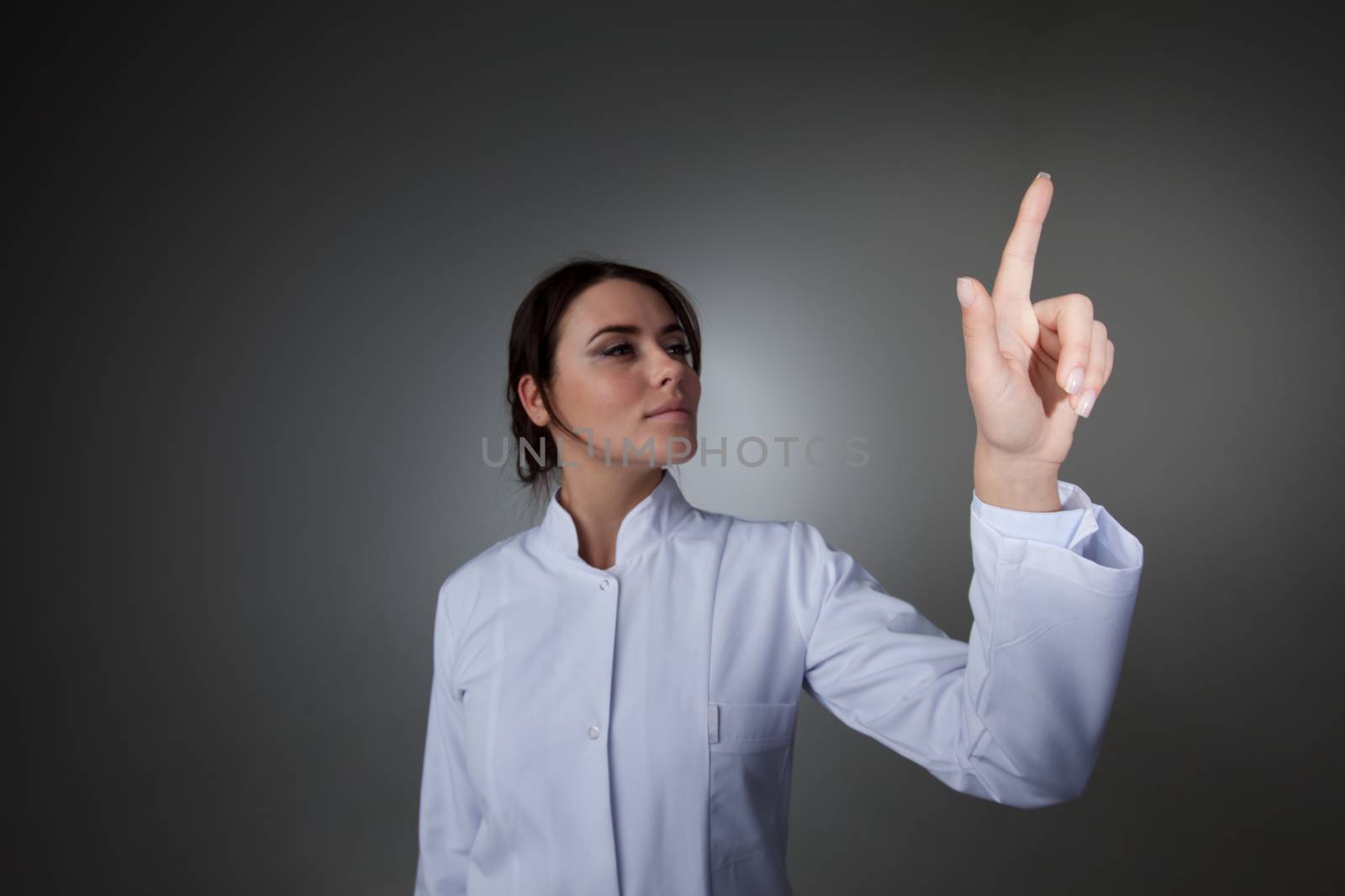 Female scientist or doctor pointing to futuristic display