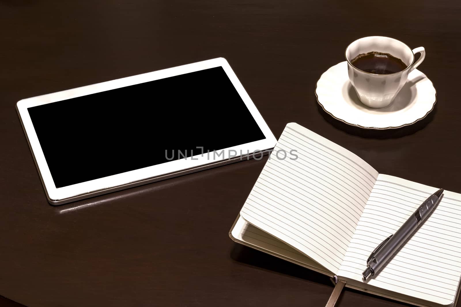 Work table: tablet PC, glasses, notebook, pencil and coffee. Gadgets on a wooden table.