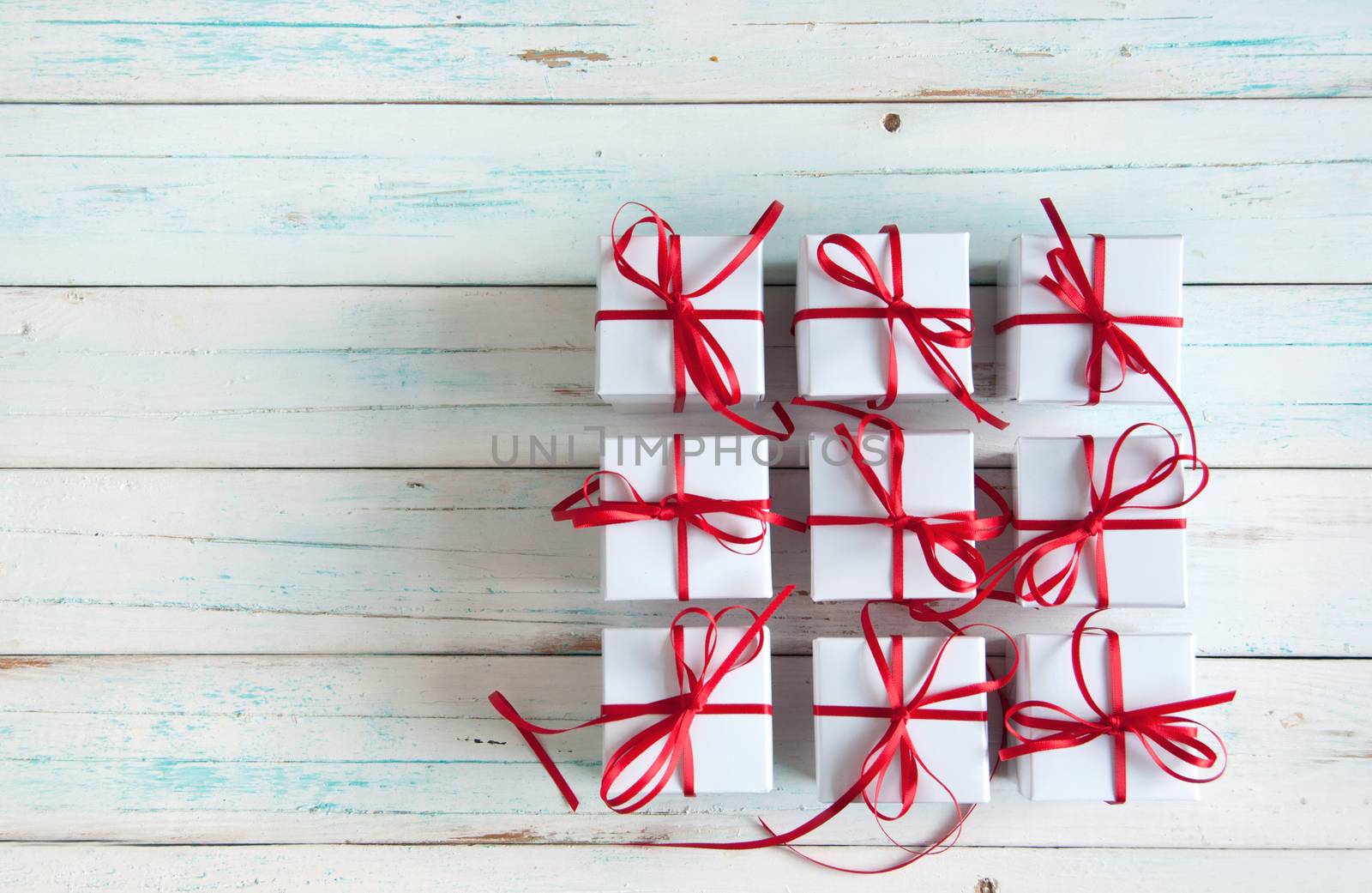 White gift boxes tied with red ribbon with space