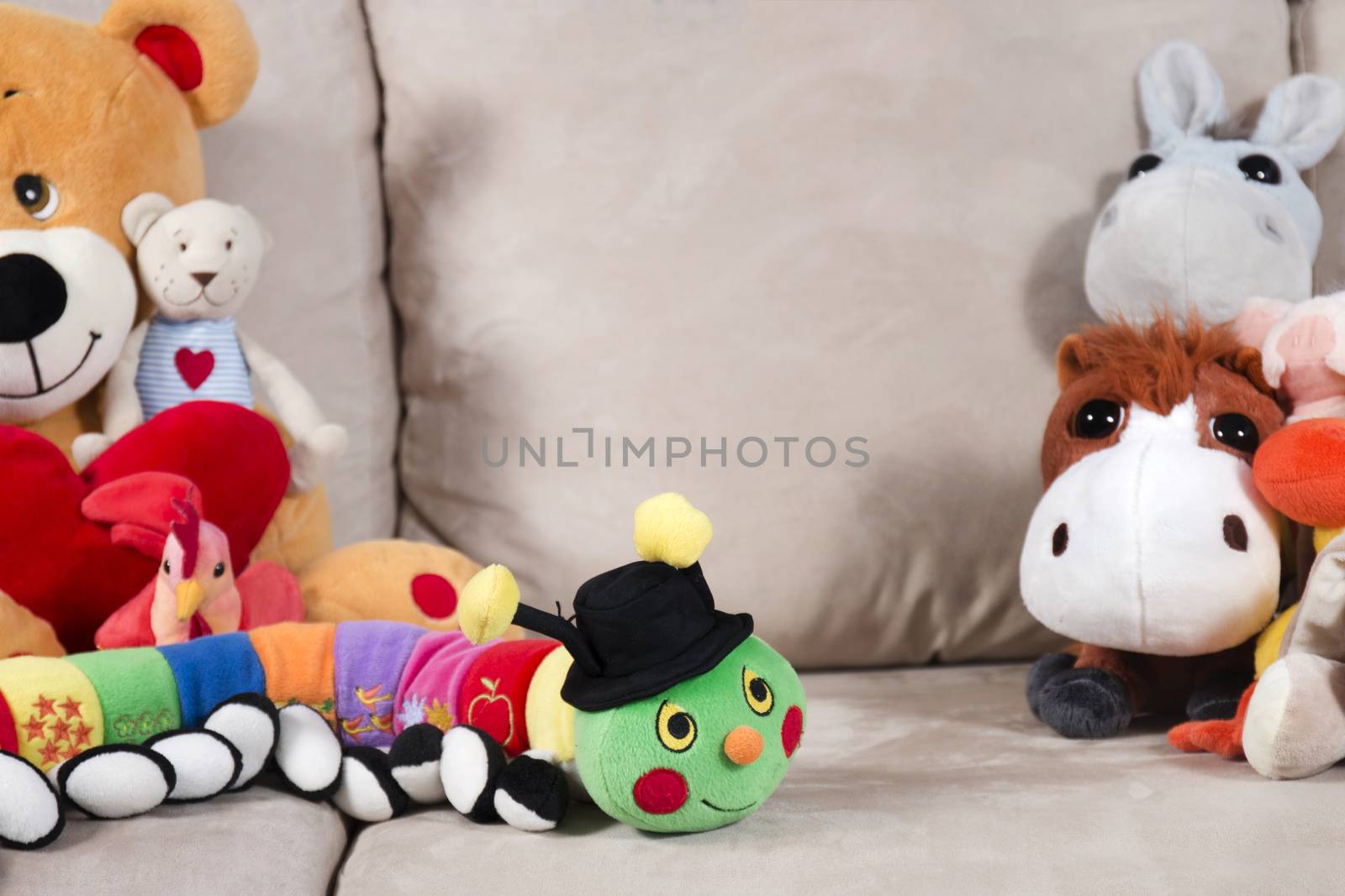 Group of stuffed toys on a sofa.