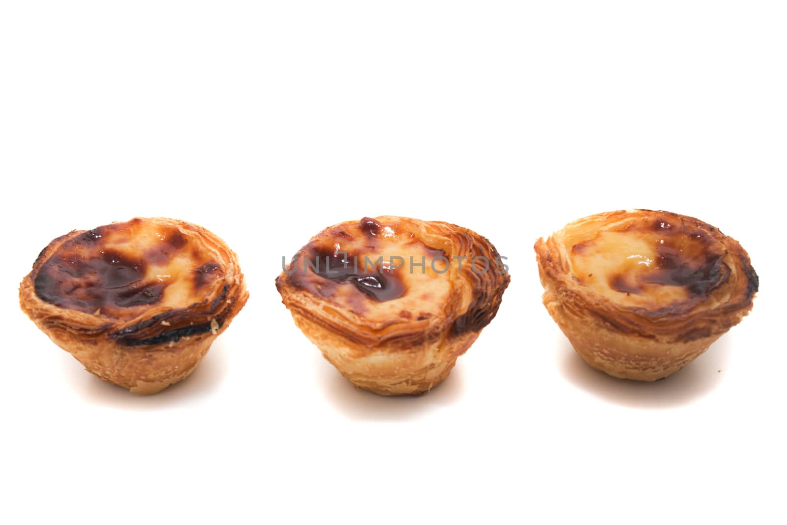 Famous Portuguese egg pastry tart called 'Pastel de Belem' isolated on white background.