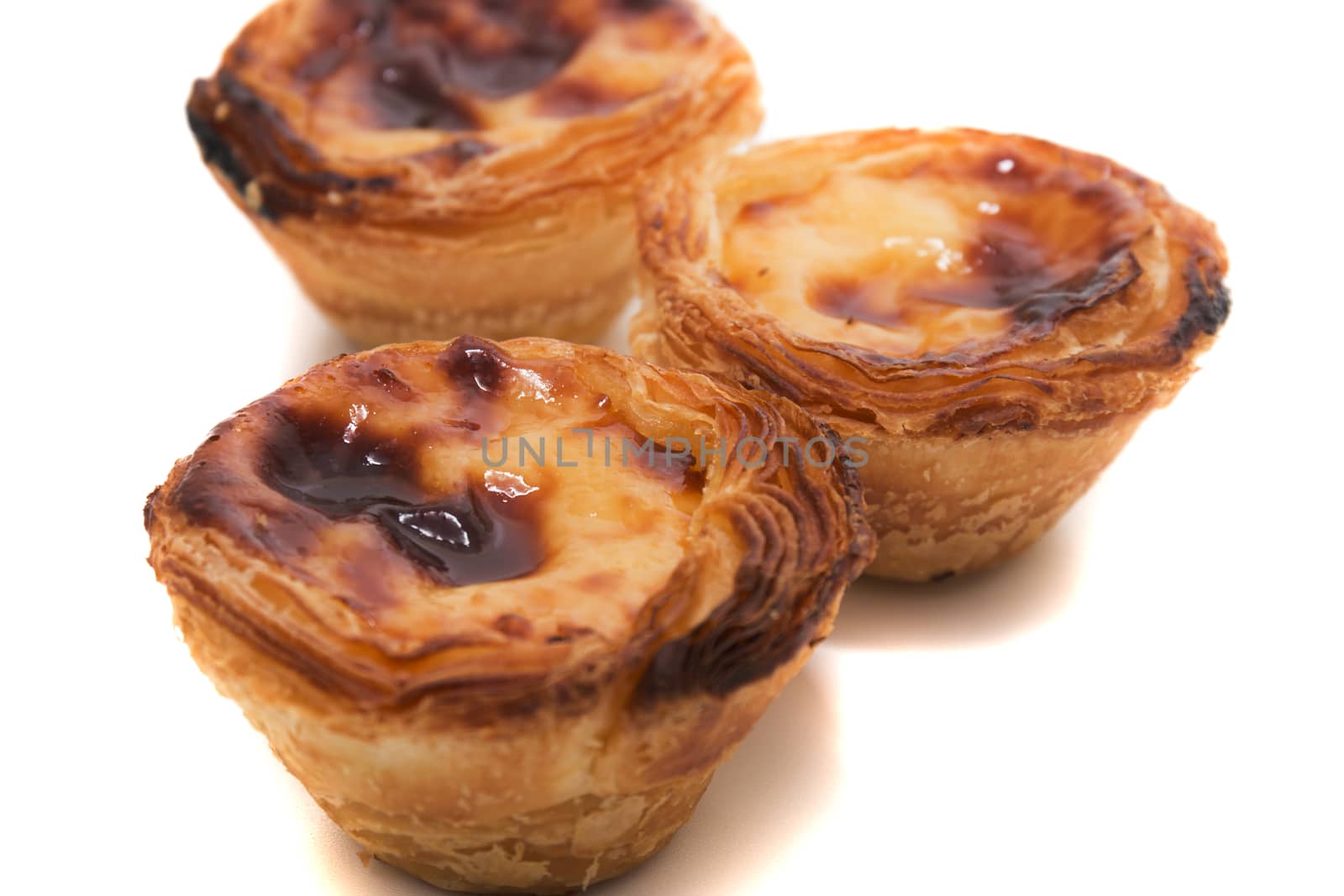 Famous Portuguese egg pastry tart called 'Pastel de Belem' isolated on white background.