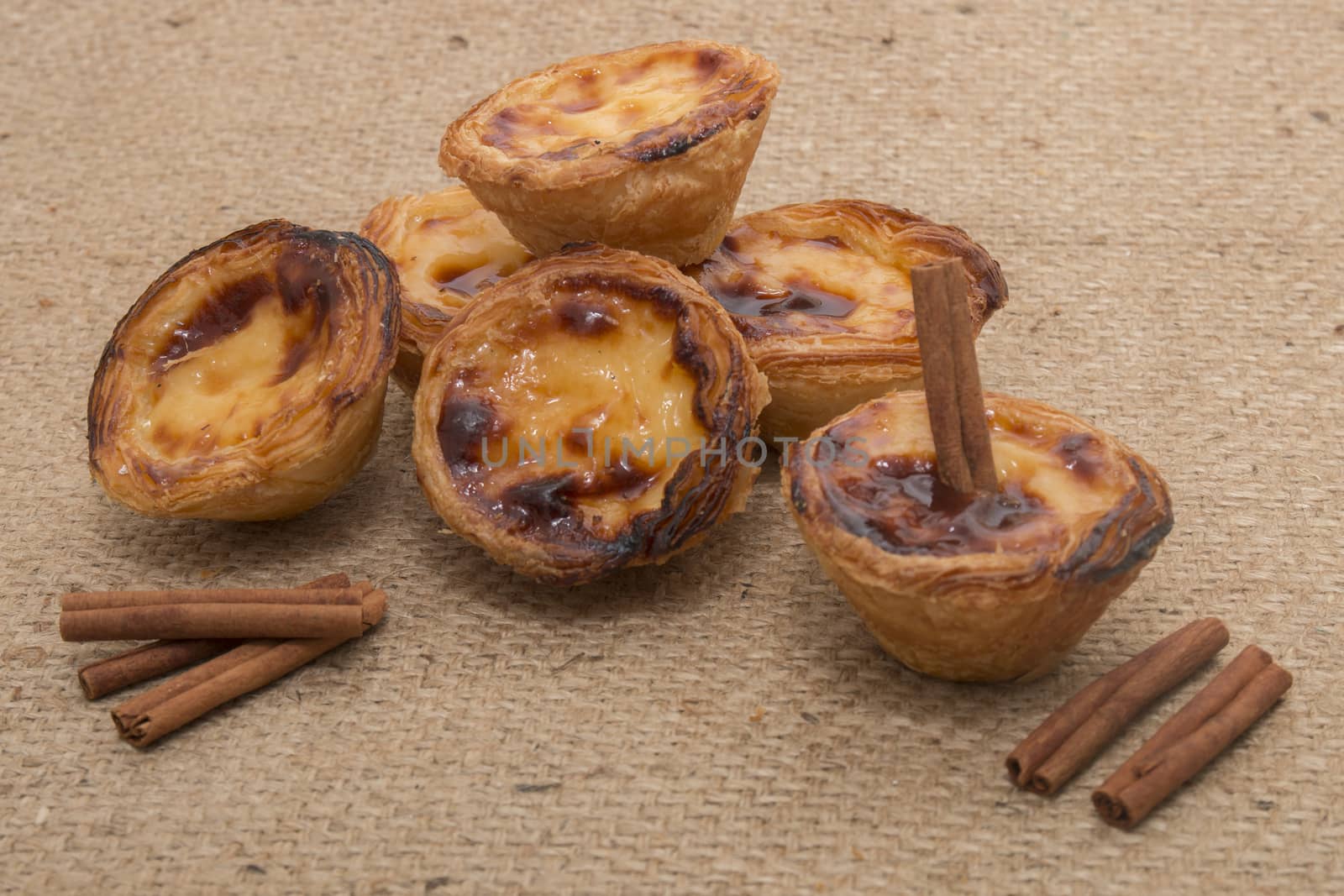 Famous Portuguese egg pastry tart called 'Pastel de Belem' on hessian fabric.
