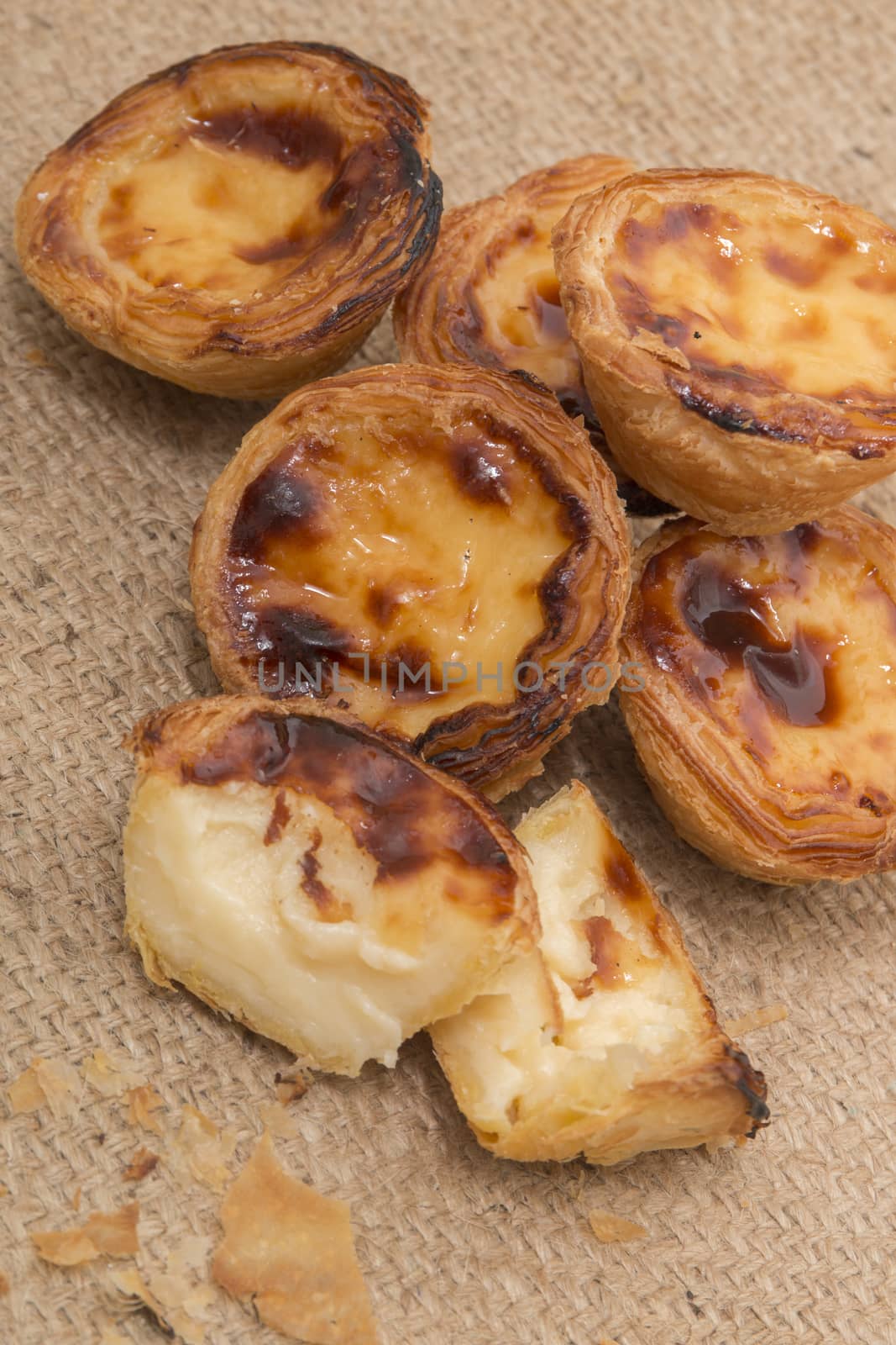 Famous Portuguese egg pastry tart called 'Pastel de Belem' on hessian fabric.