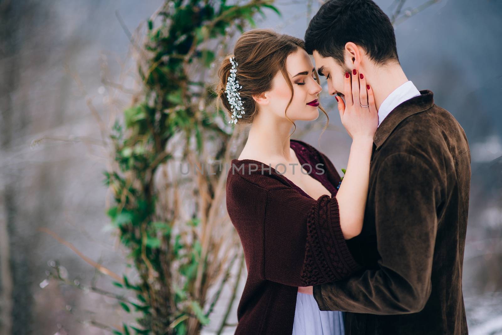 groom in a brown and bride in burgundy in the mountains Carpathians