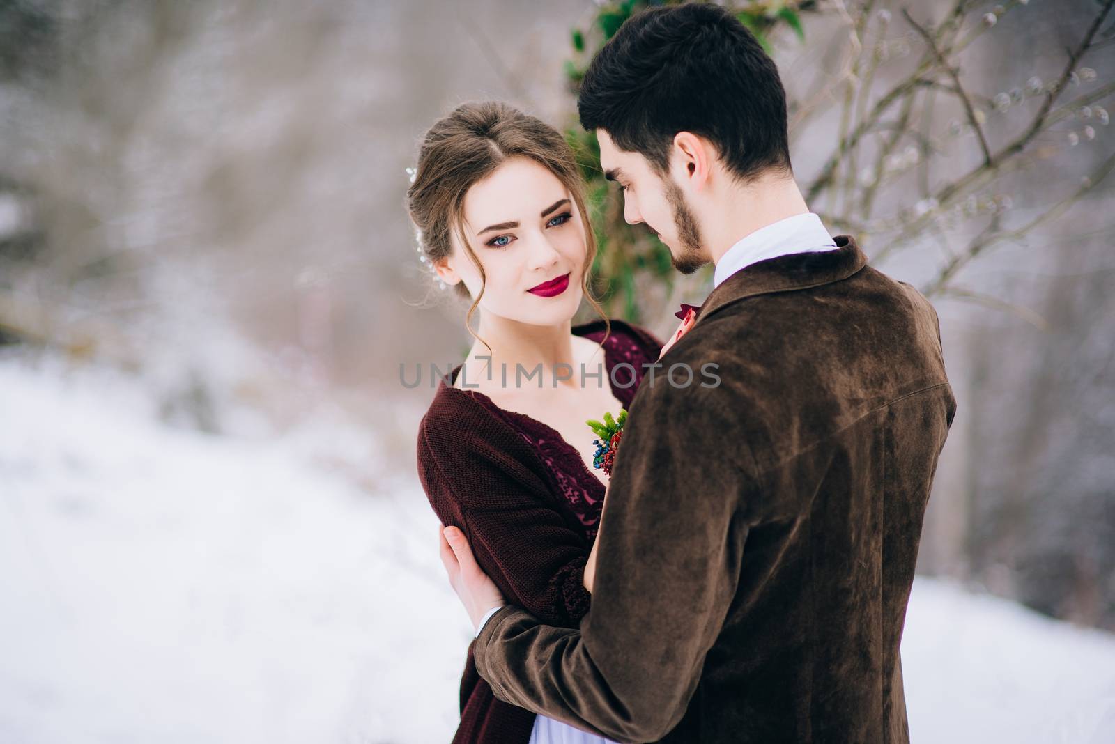 groom in a brown and bride in burgundy in the mountains Carpathians