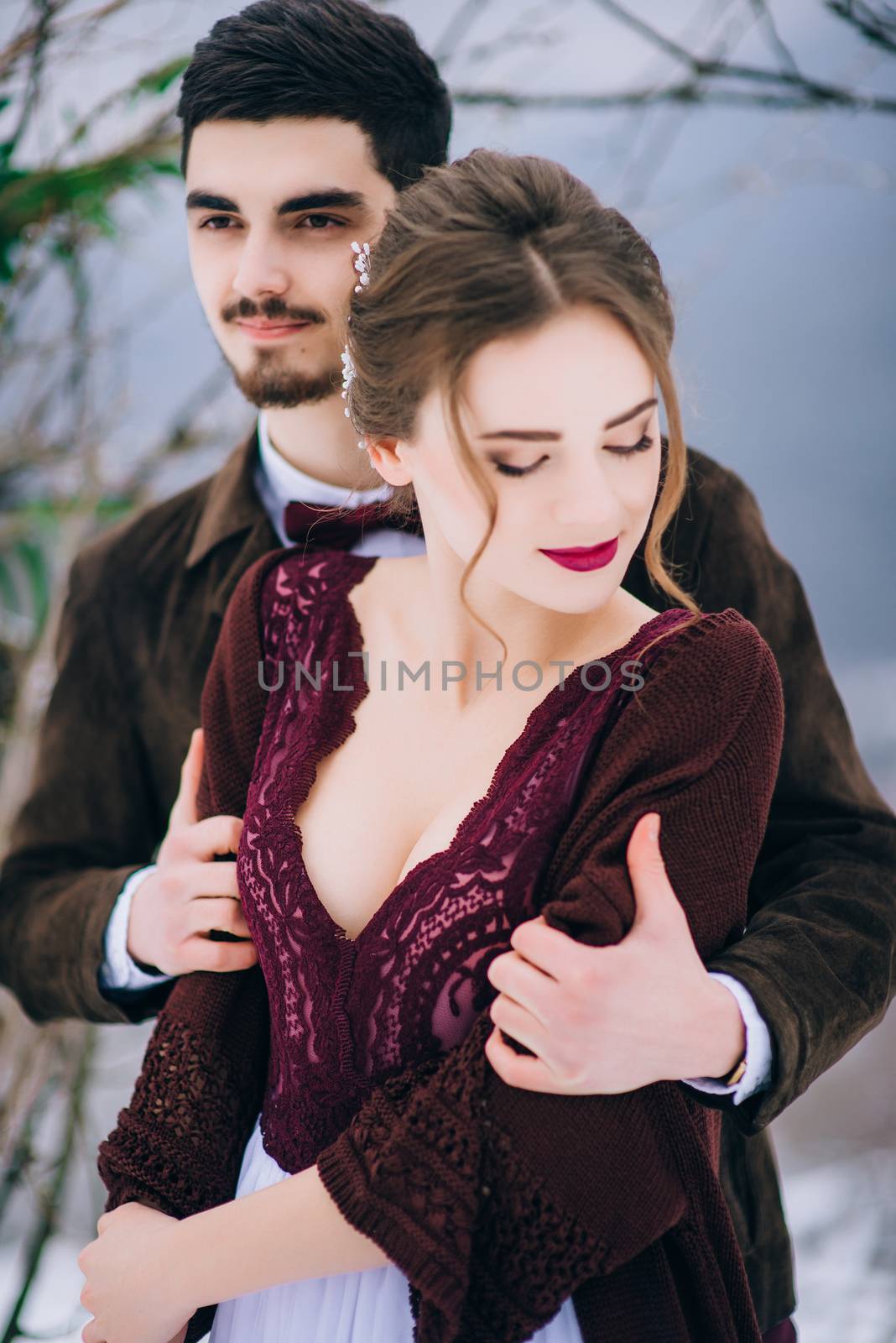 groom in a brown and bride in burgundy in the mountains Carpathians