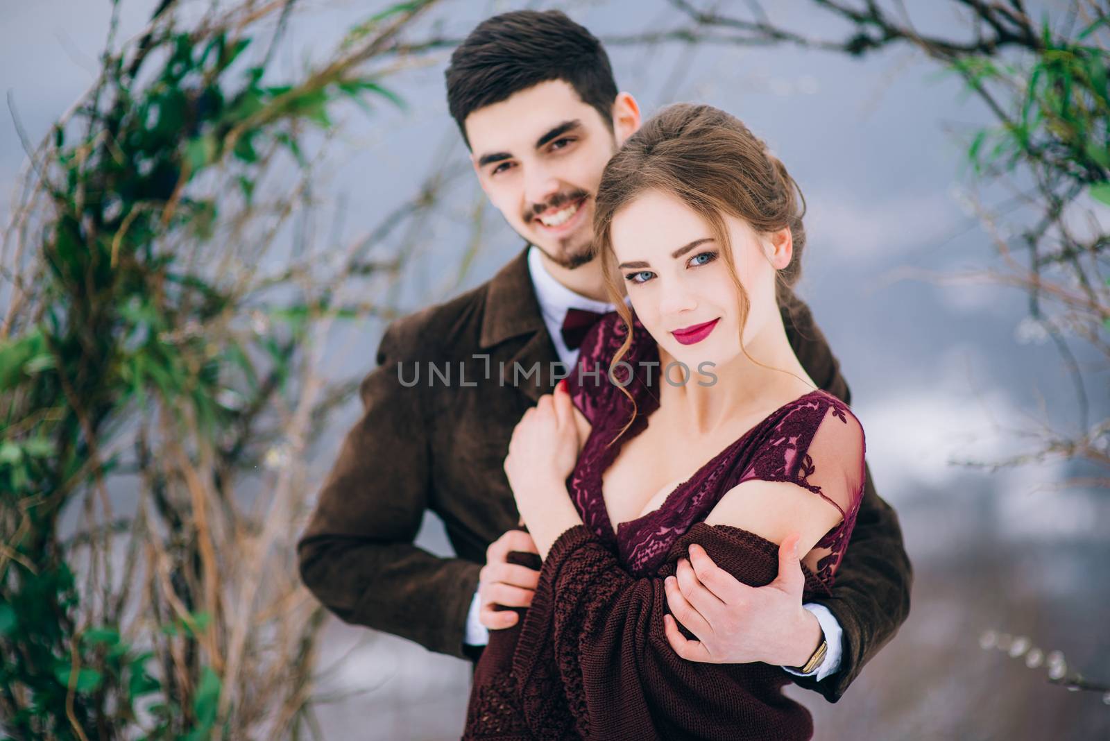 groom in a brown and bride in burgundy in the mountains Carpathians